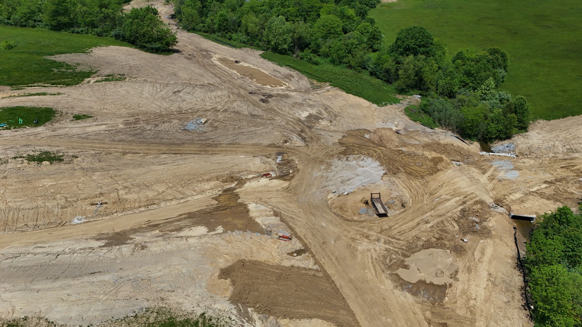 An aerial view of a dirt road surrounded by trees.