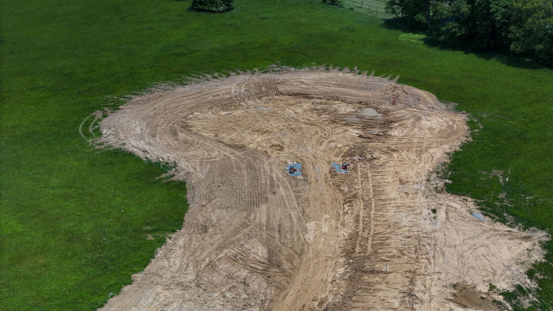 An aerial view of a dirt road in a grassy field.