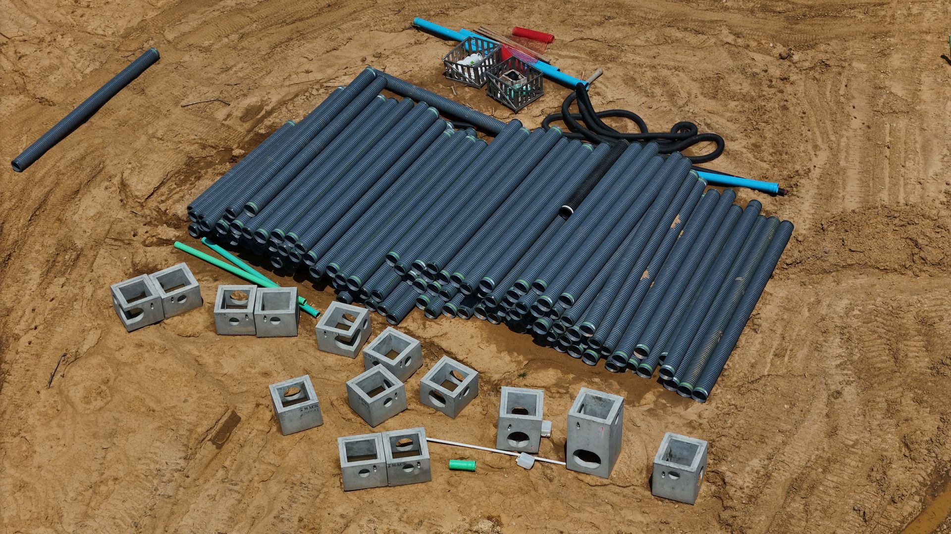 A pile of plastic pipes and blocks are laying on the ground.
