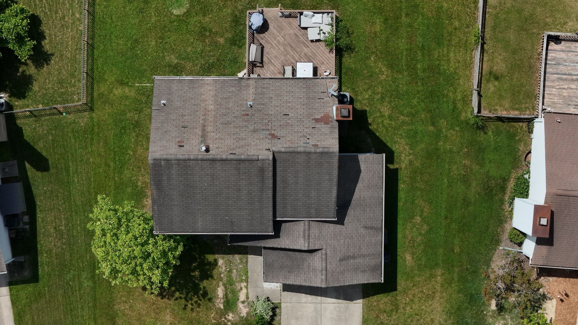 An aerial view of a house with a deck and a lot of grass.