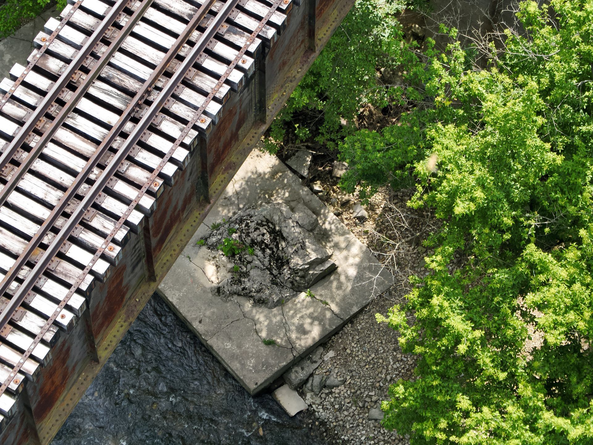 An aerial view of a train track with trees in the background.