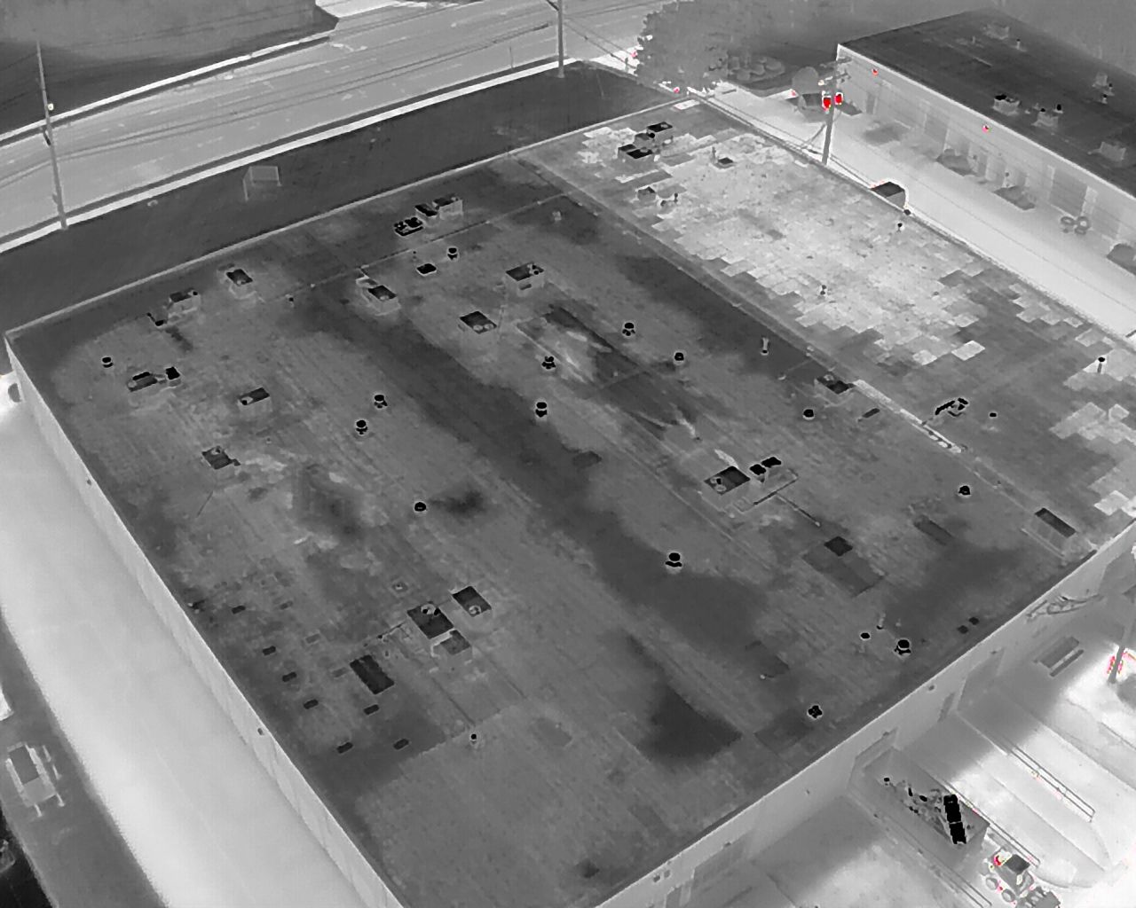 An aerial view of a large building with a lot of cars parked on the roof.