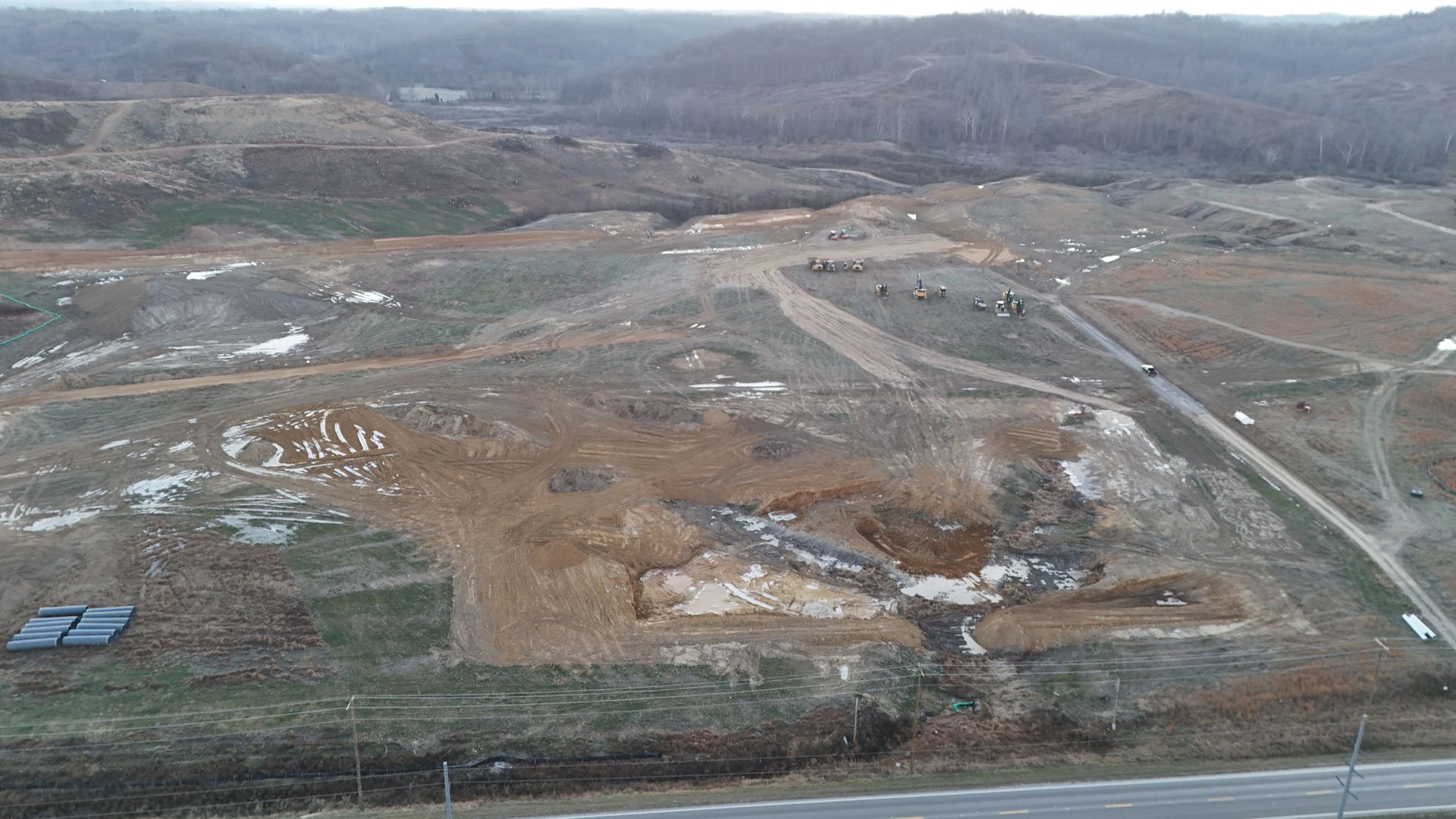 An aerial view of a construction site next to a highway.