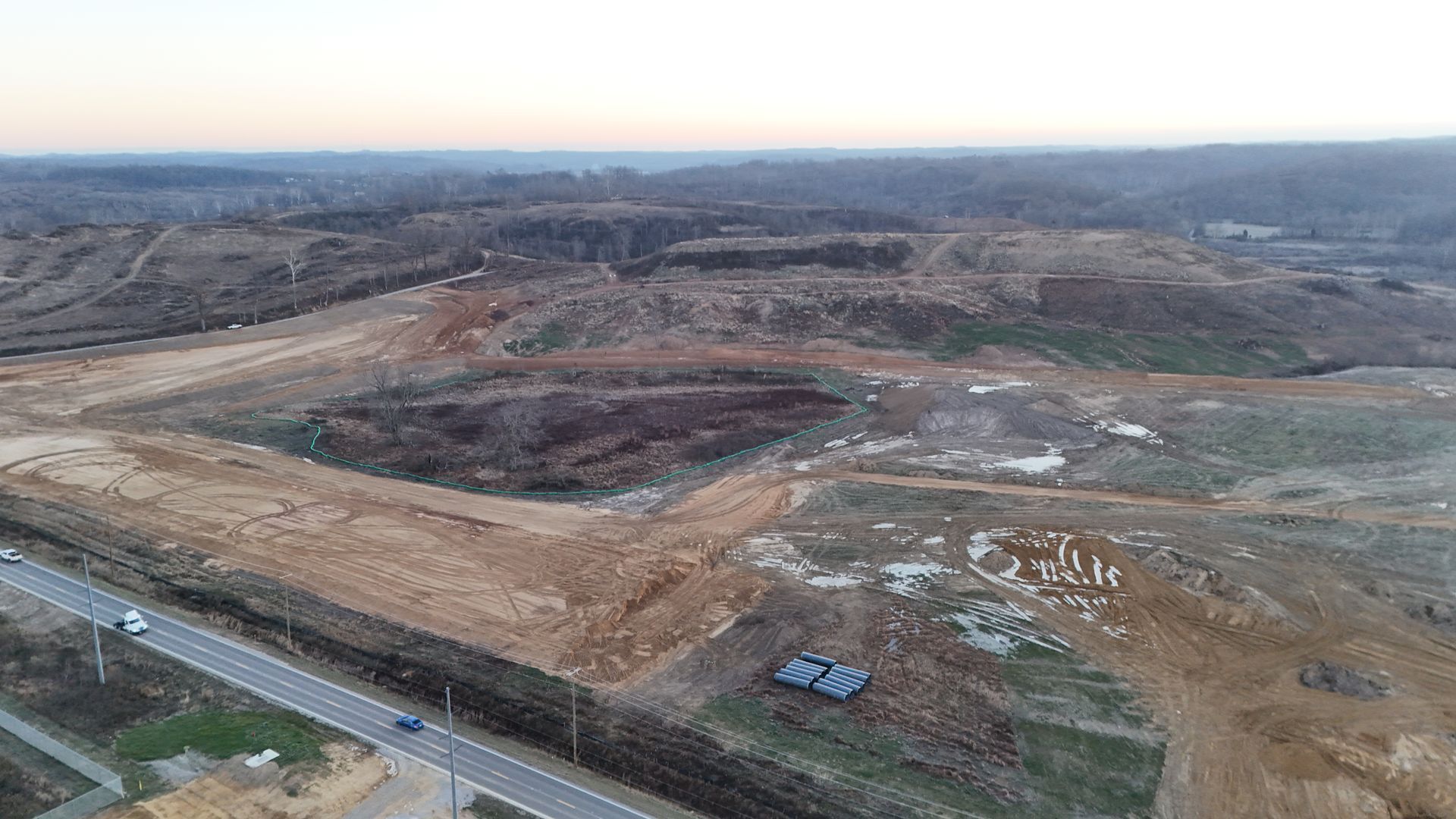 An aerial view of a construction site with a road going through it.