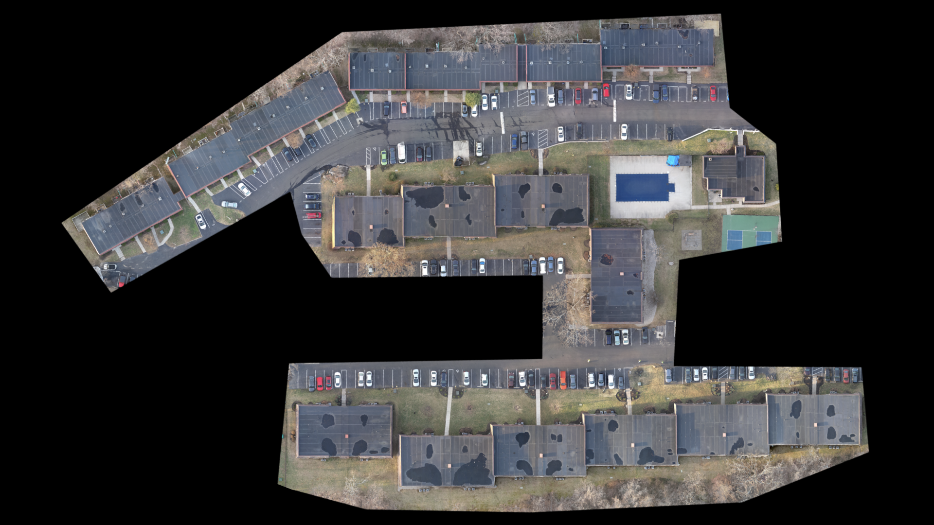 An aerial view of a large building with a lot of parking spaces.