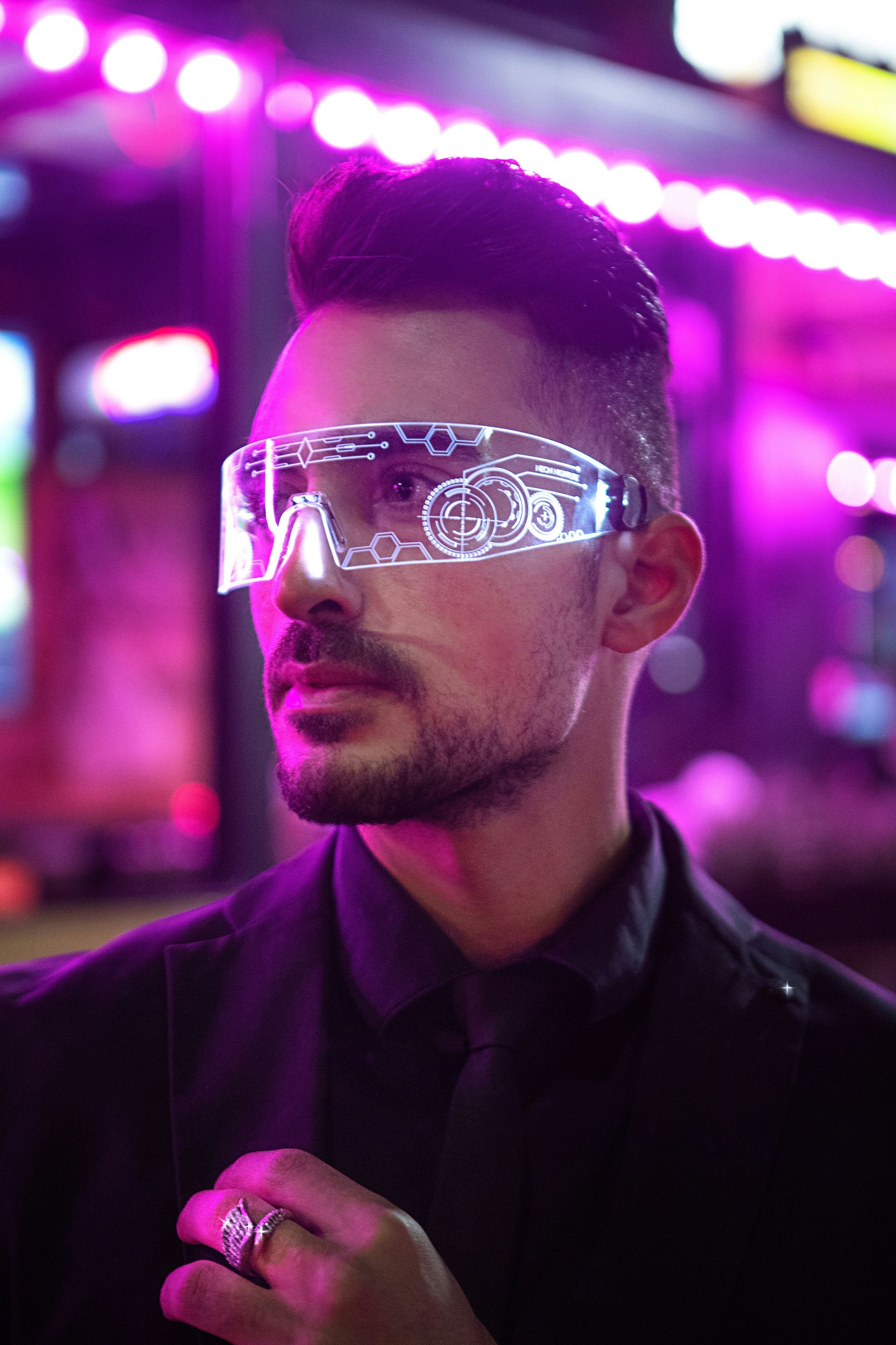 A man in a suit and tie is wearing glow in the dark goggles.
