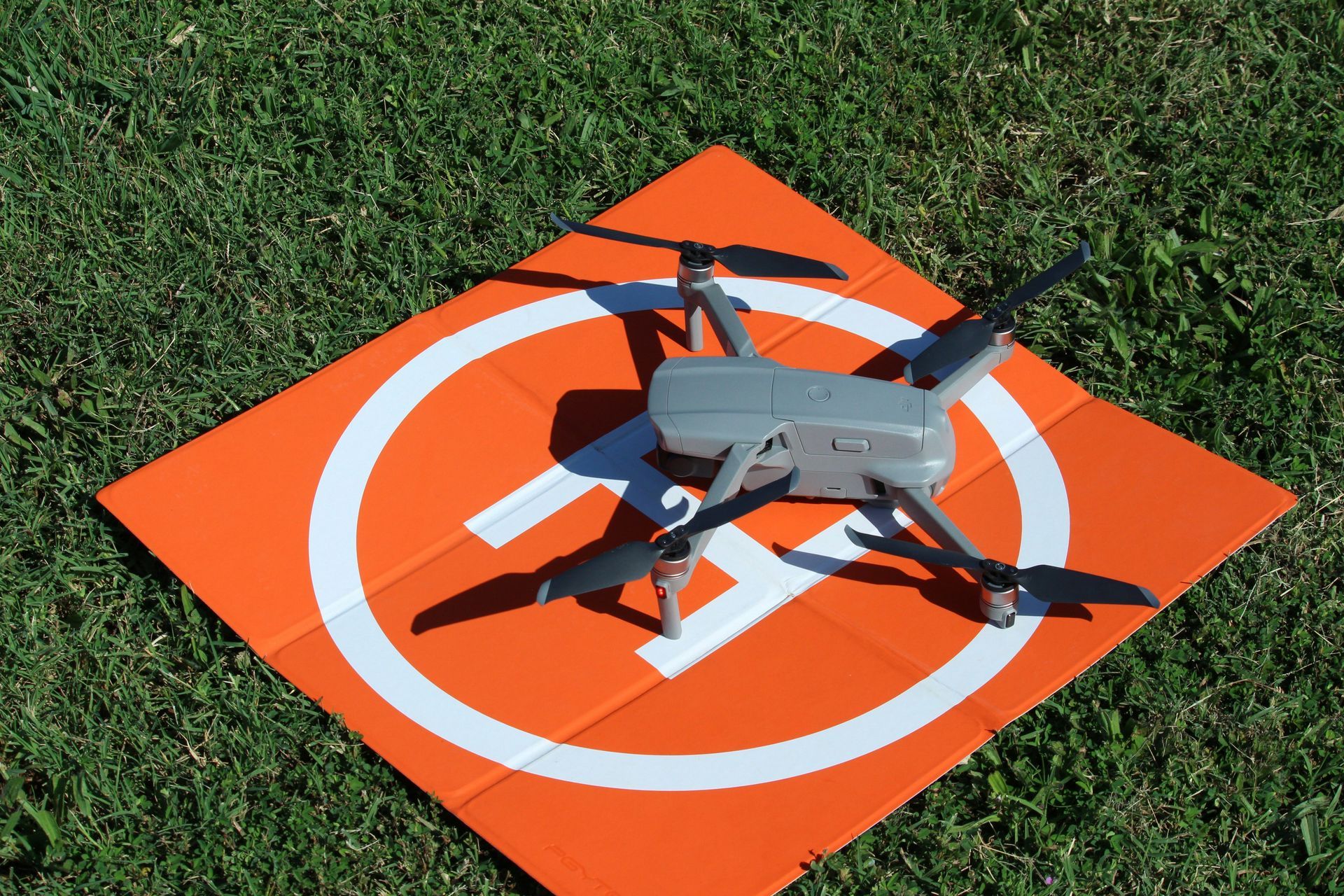 A drone is sitting on top of an orange landing pad.