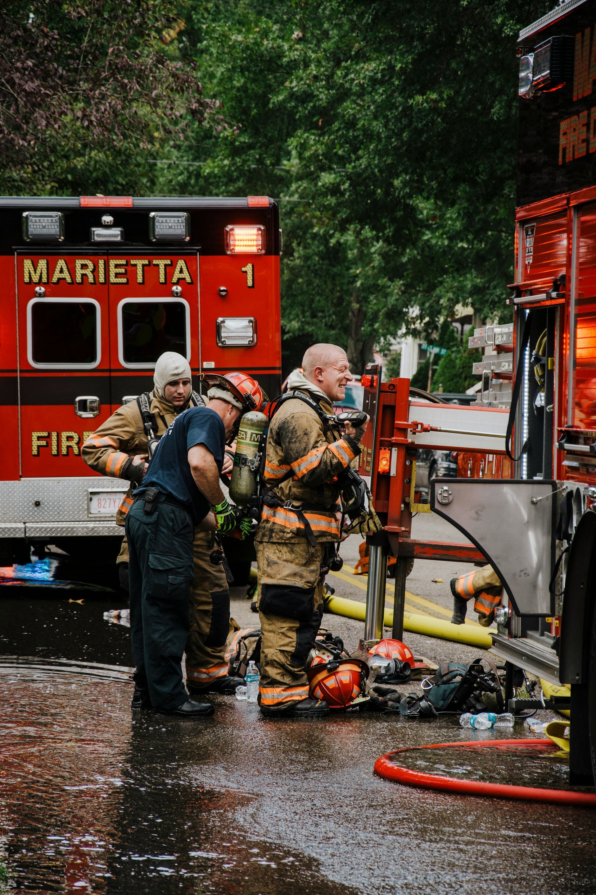 Firefighters at a scene, near an ambulance and truck, in Marietta, Georgia.