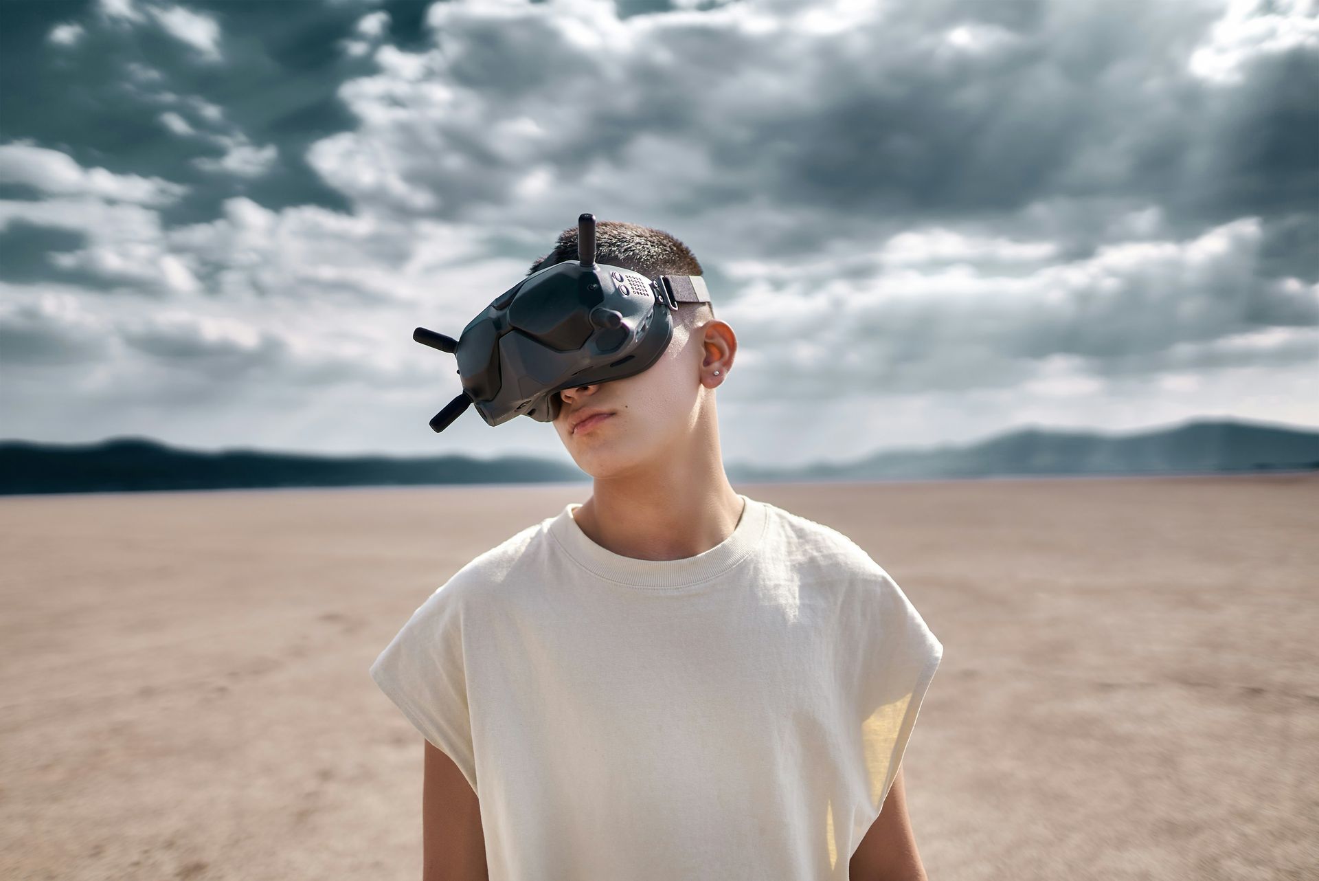 A young boy wearing a virtual reality headset in the desert.