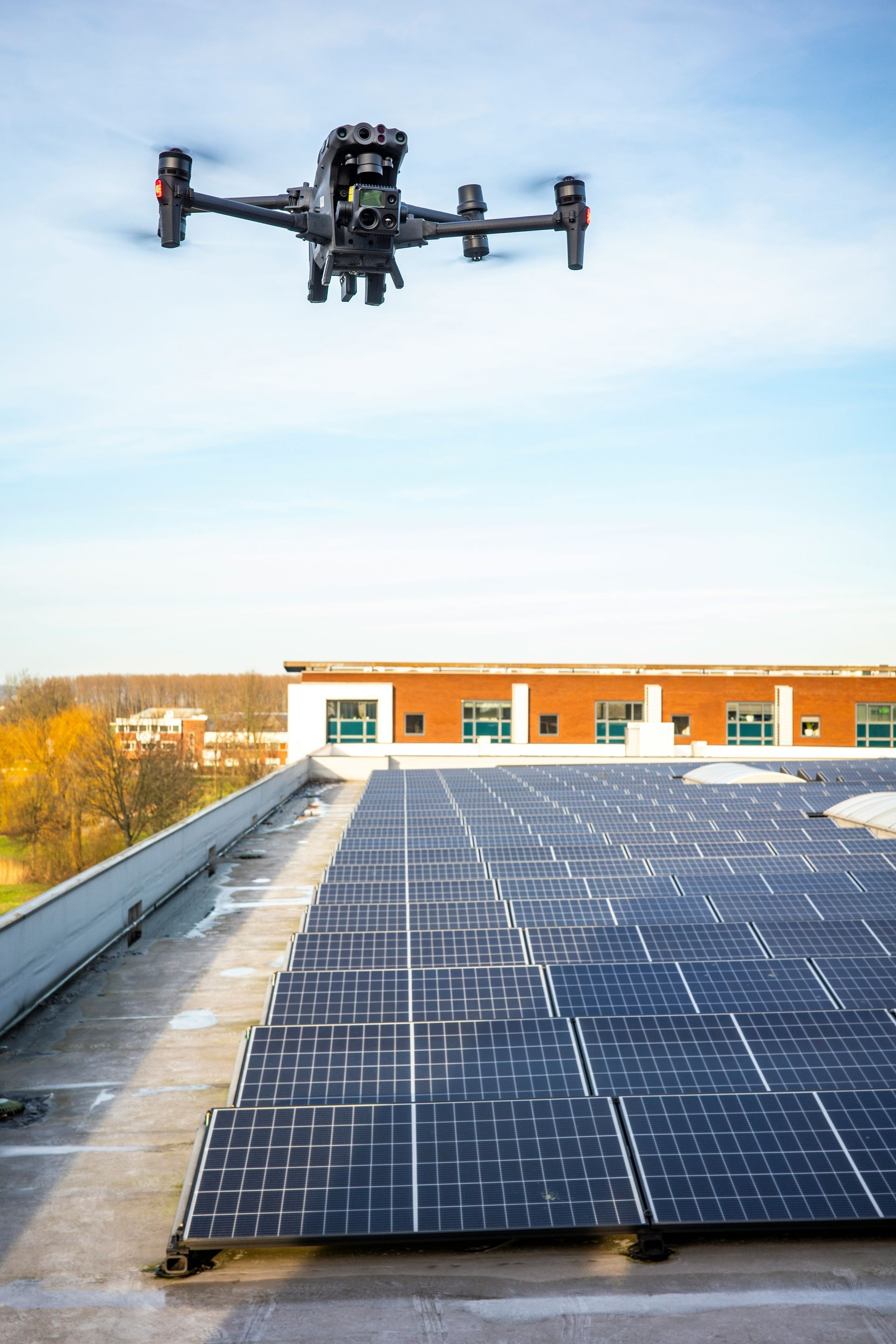 A drone is flying over a roof with solar panels.