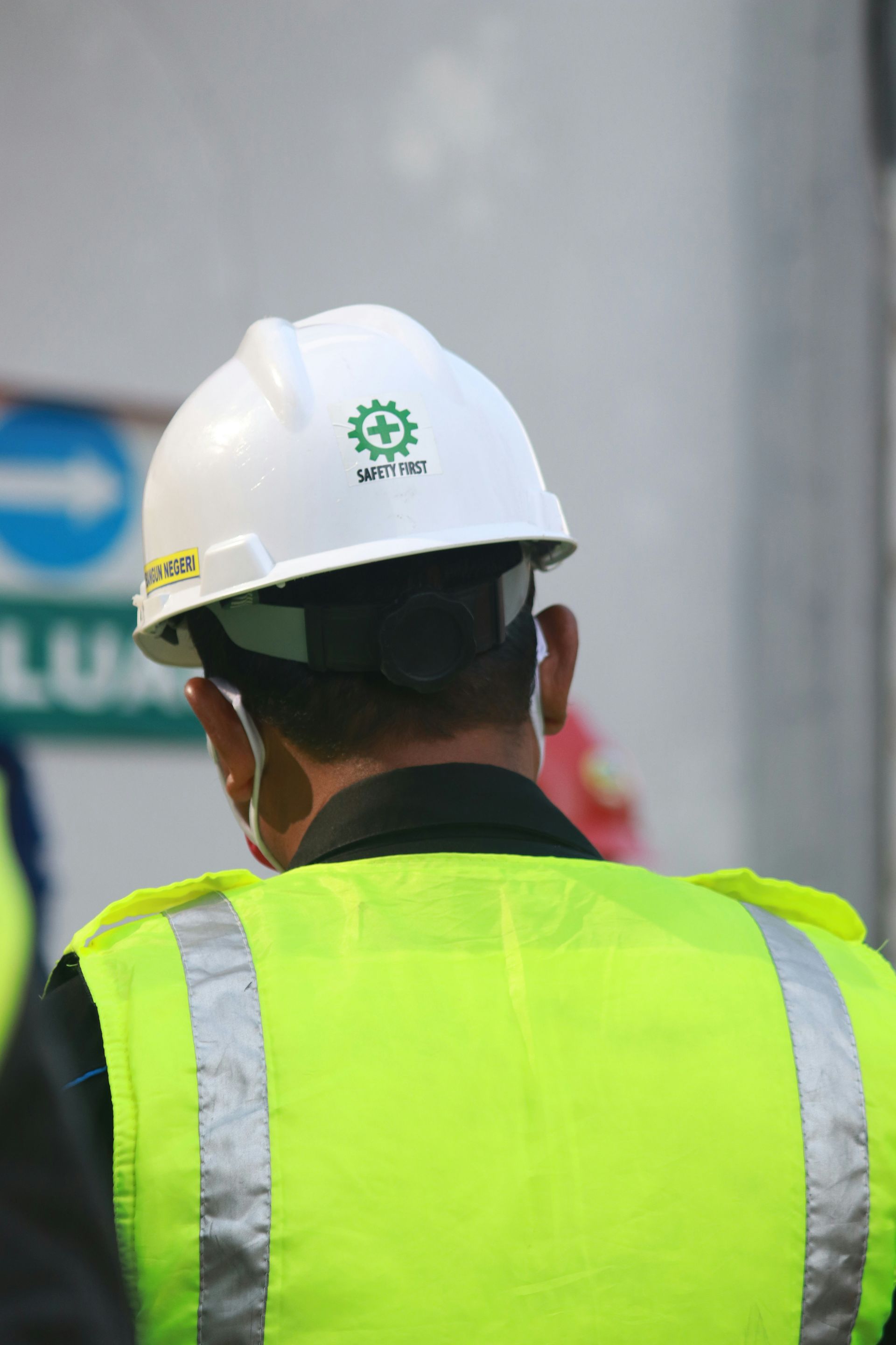 A man wearing a hard hat and a yellow vest