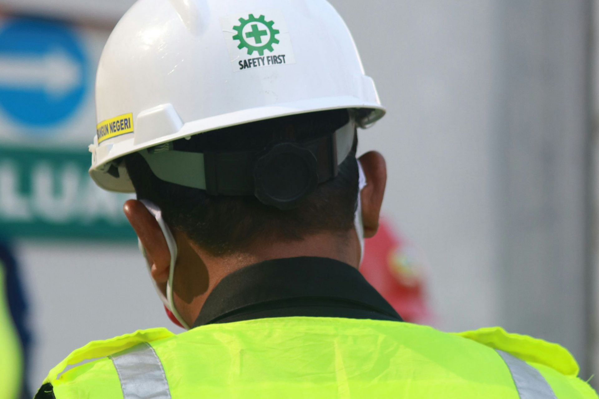 A man wearing a hard hat and a yellow vest