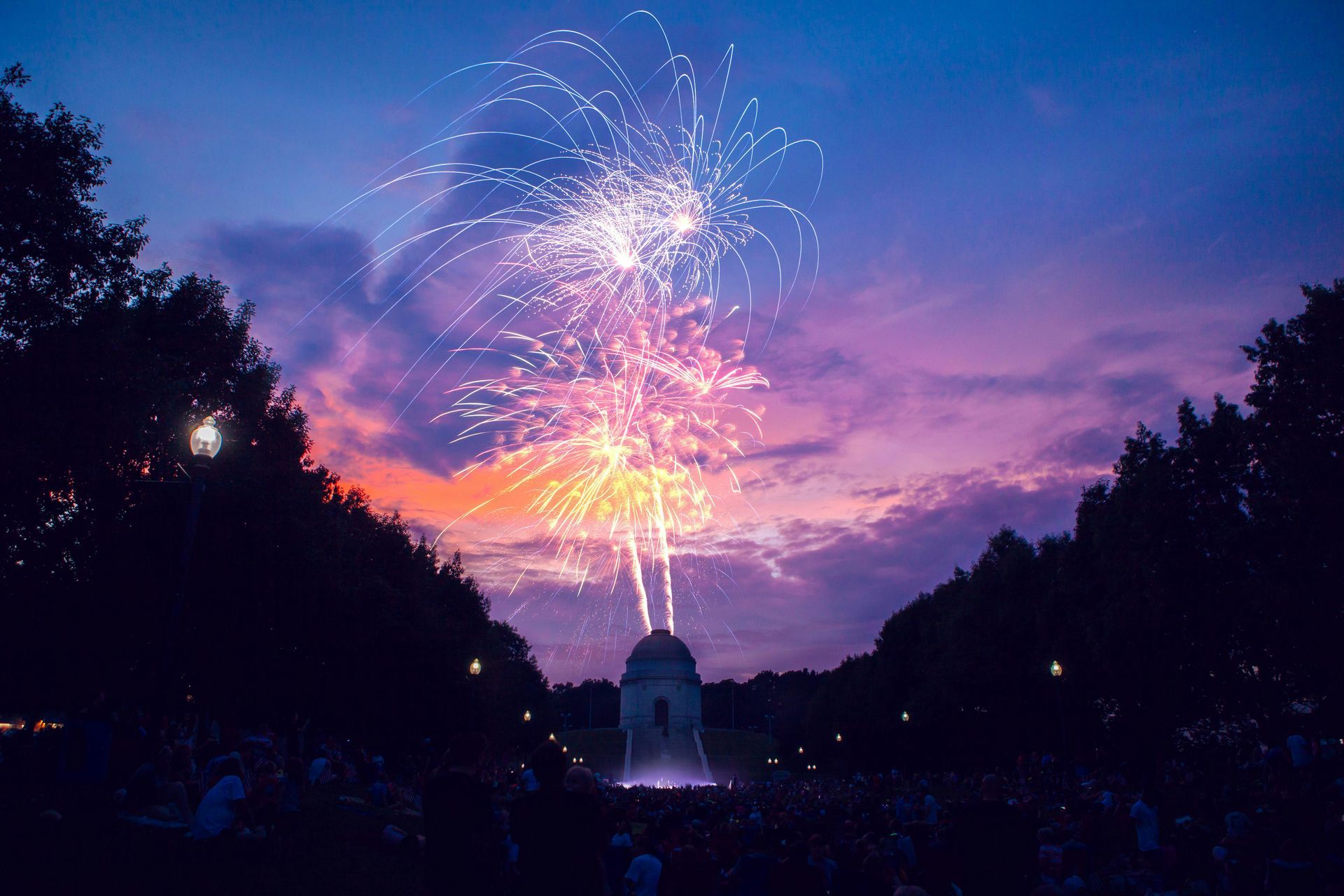 A crowd of people are watching a fireworks display at night in Ohio.