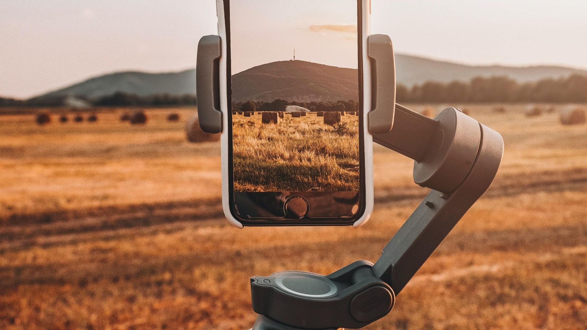 A cell phone is being used to take a picture of a field.