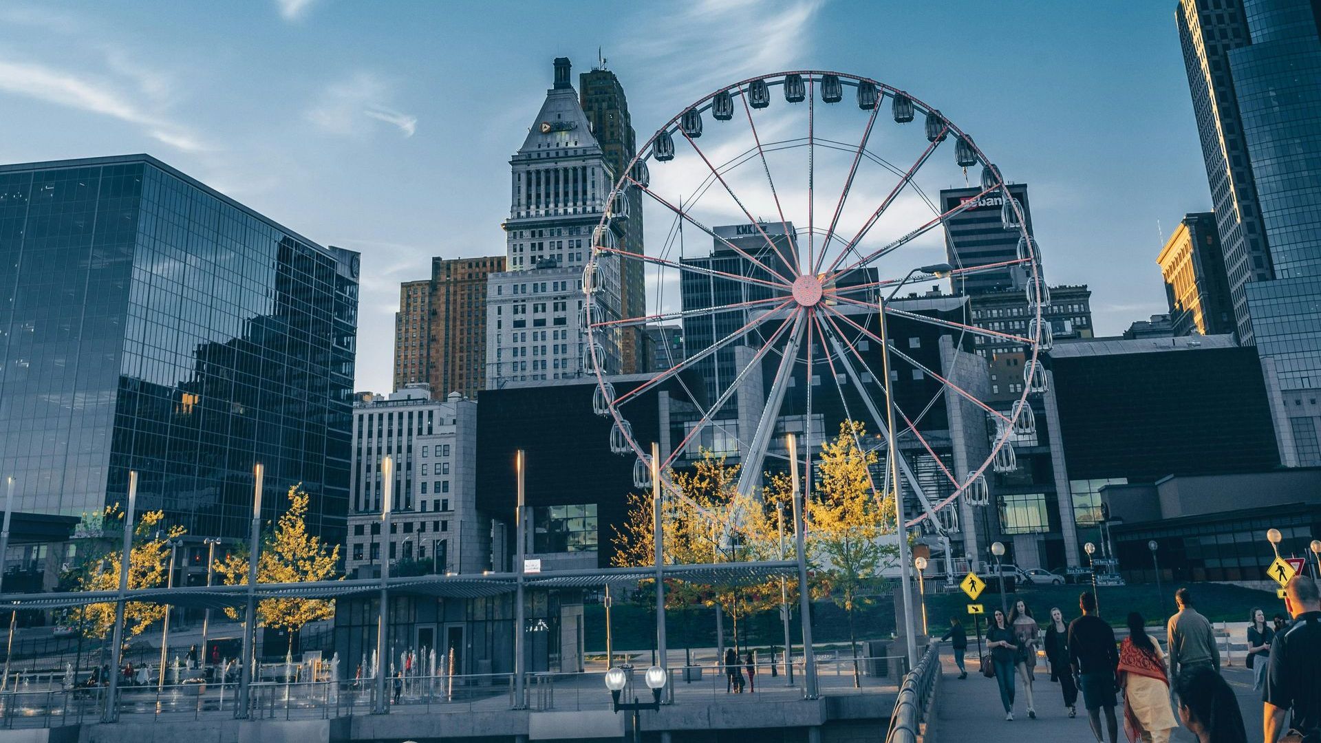 A ferris wheel is in the middle of a city surrounded by tall buildings.