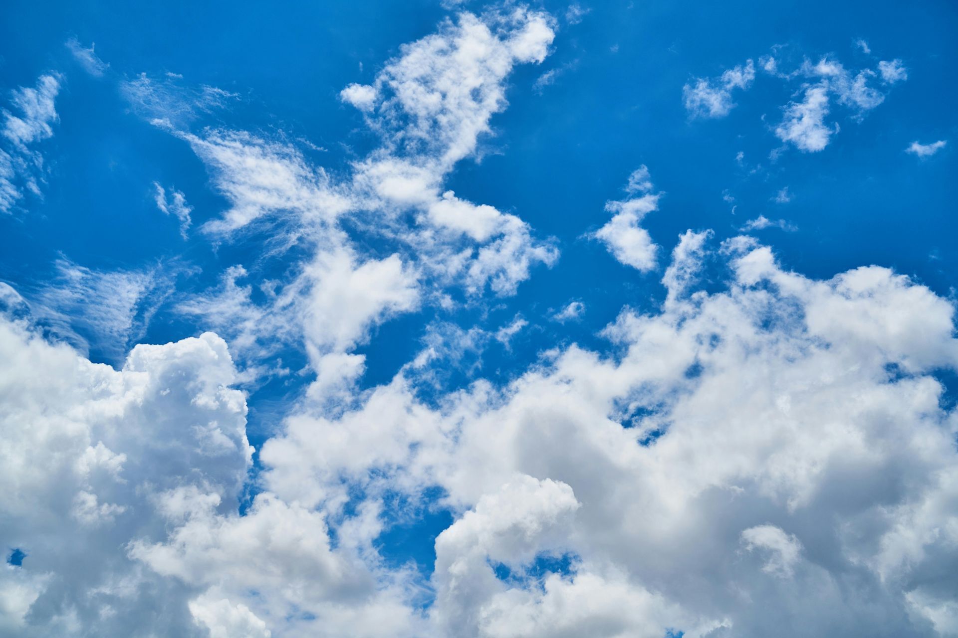 Bright blue sky with white puffy clouds.