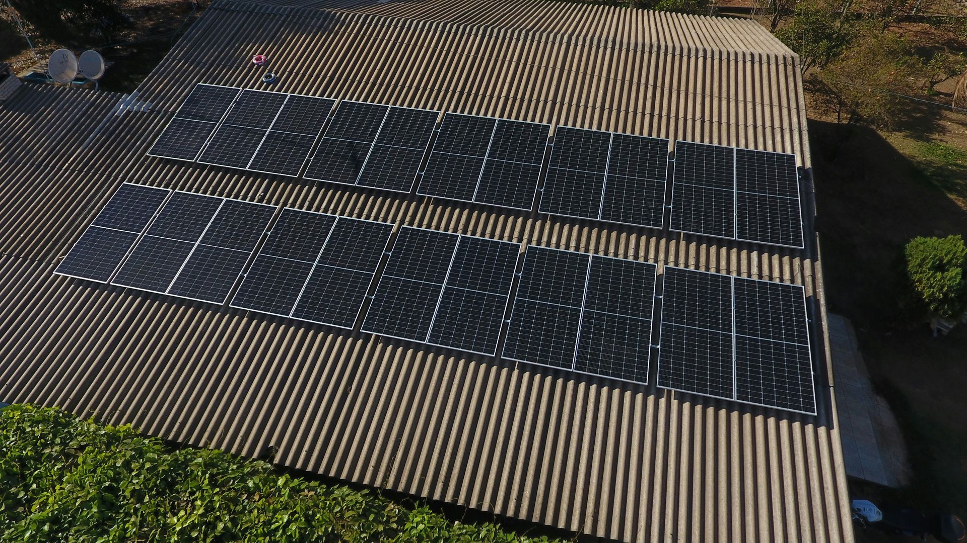 Solar panels installed on a corrugated metal roof of a house.