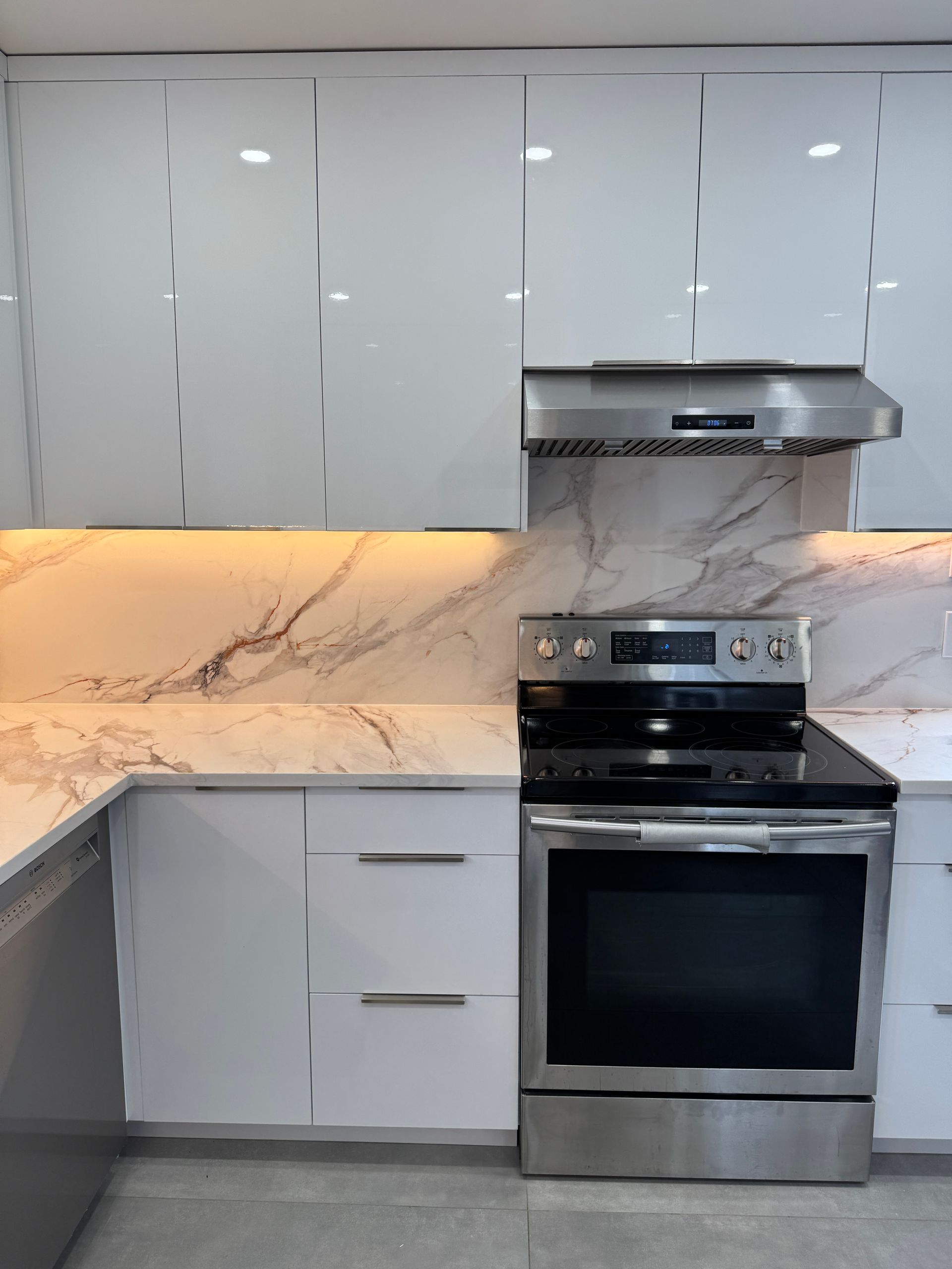 Une cuisine avec des appareils en acier inoxydable et des armoires blanches