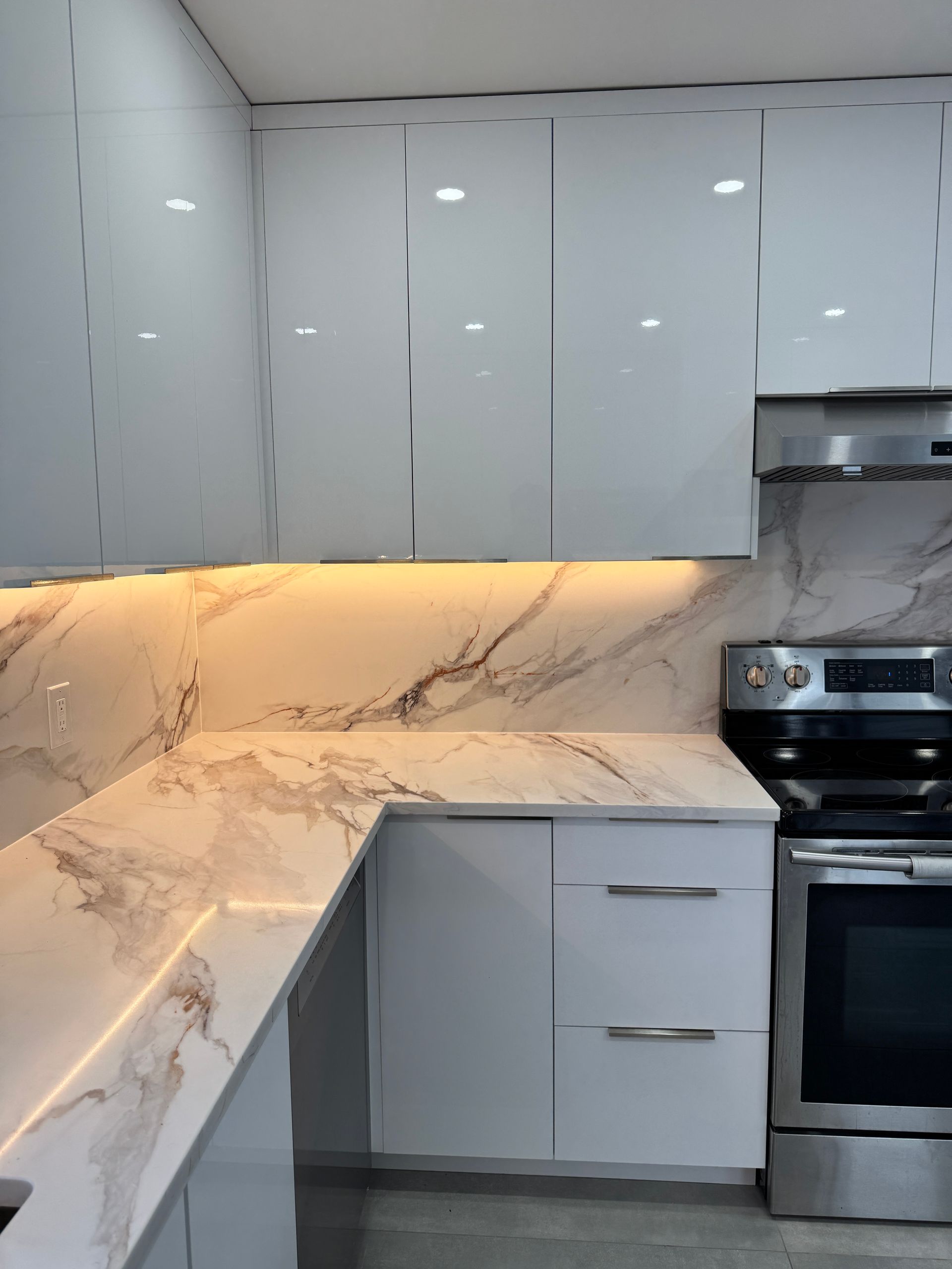 Une cuisine avec des armoires blanches et des appareils en acier inoxydable