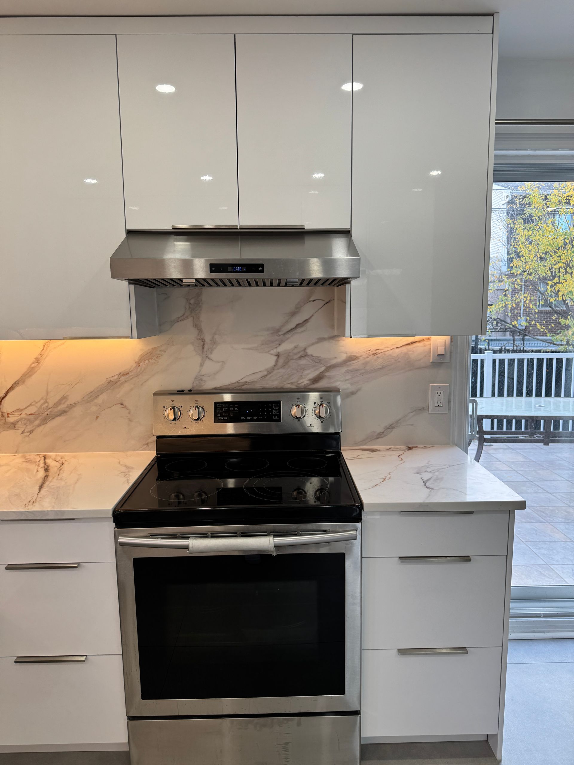 Une cuisine avec des appareils en acier inoxydable et des armoires blanches