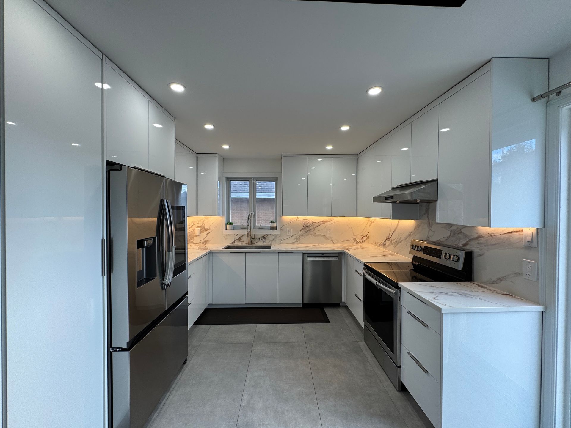 Une cuisine avec des armoires blanches et des appareils en acier inoxydable