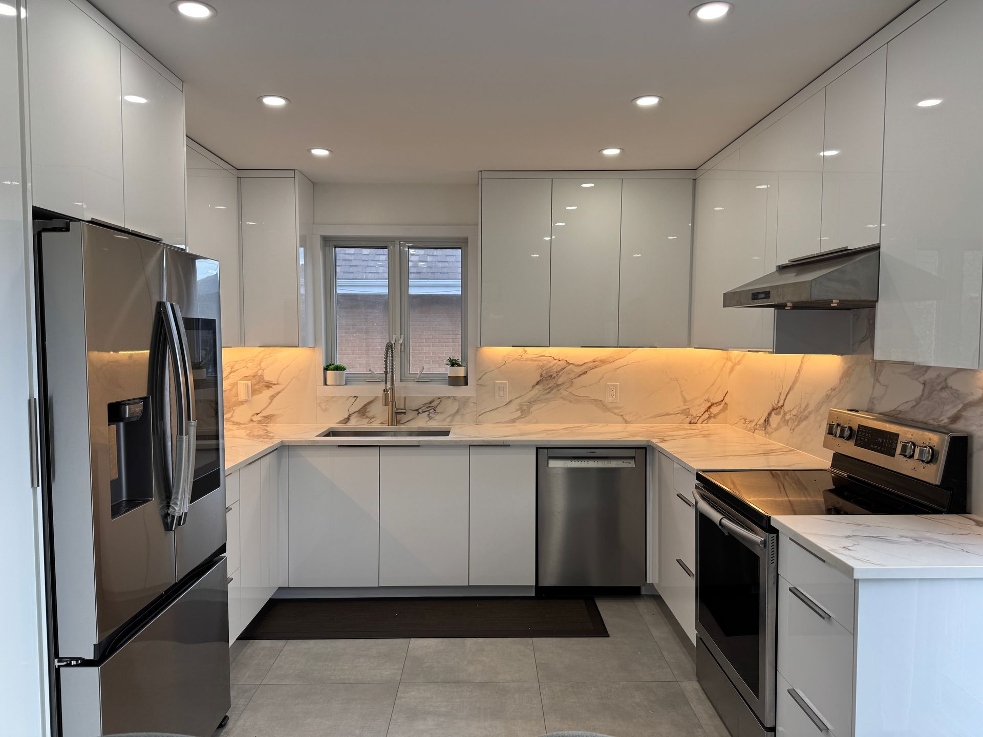 Une cuisine avec des armoires blanches et des appareils électroménagers en acier inoxydable.