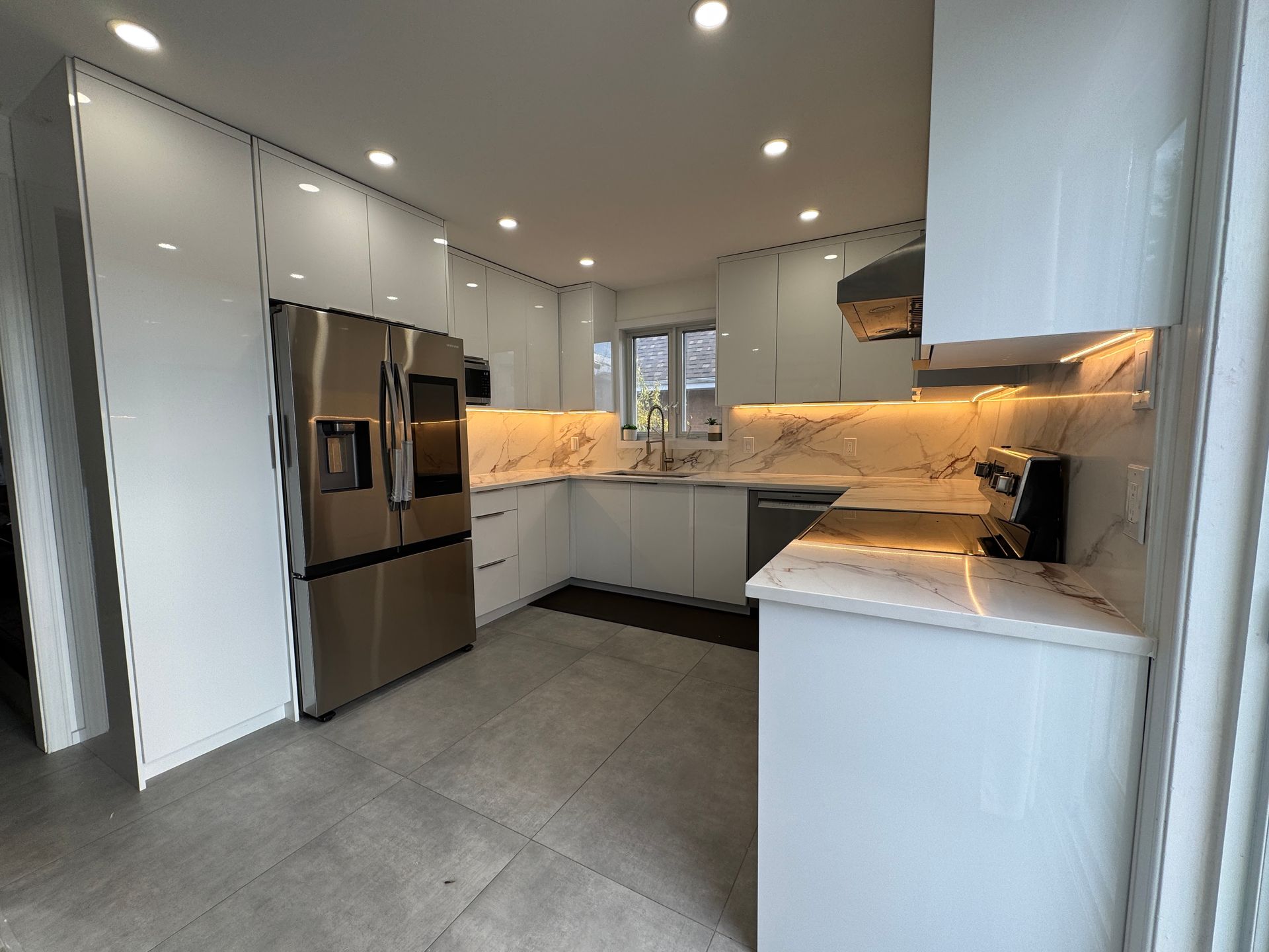 Une cuisine avec des armoires blanches et des appareils électroménagers en acier inoxydable.