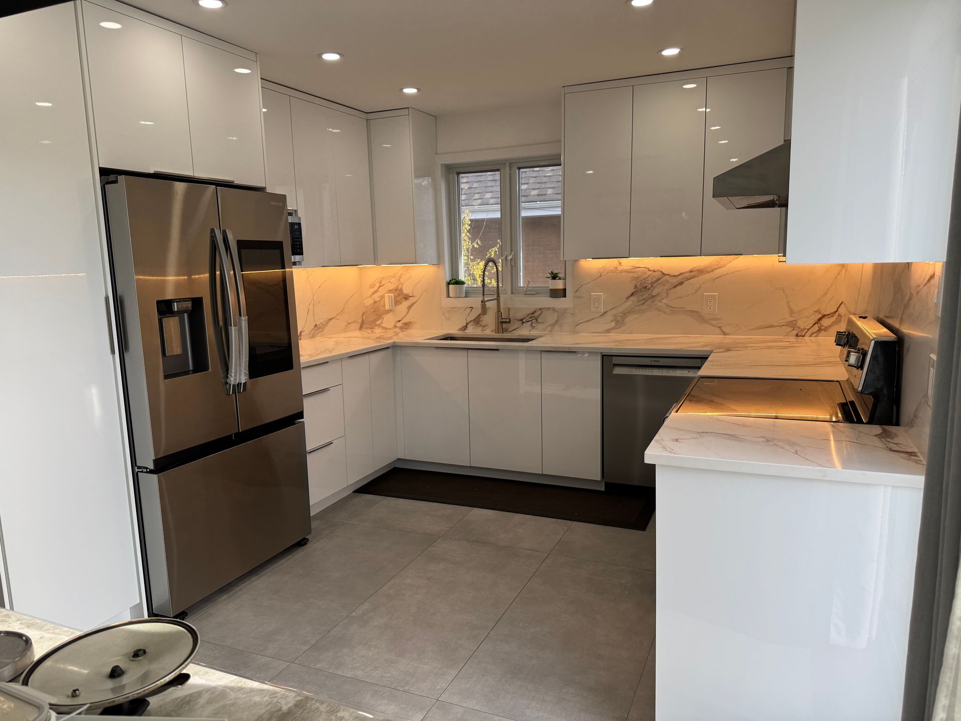 Une cuisine avec des armoires blanches et des appareils électroménagers en acier inoxydable.