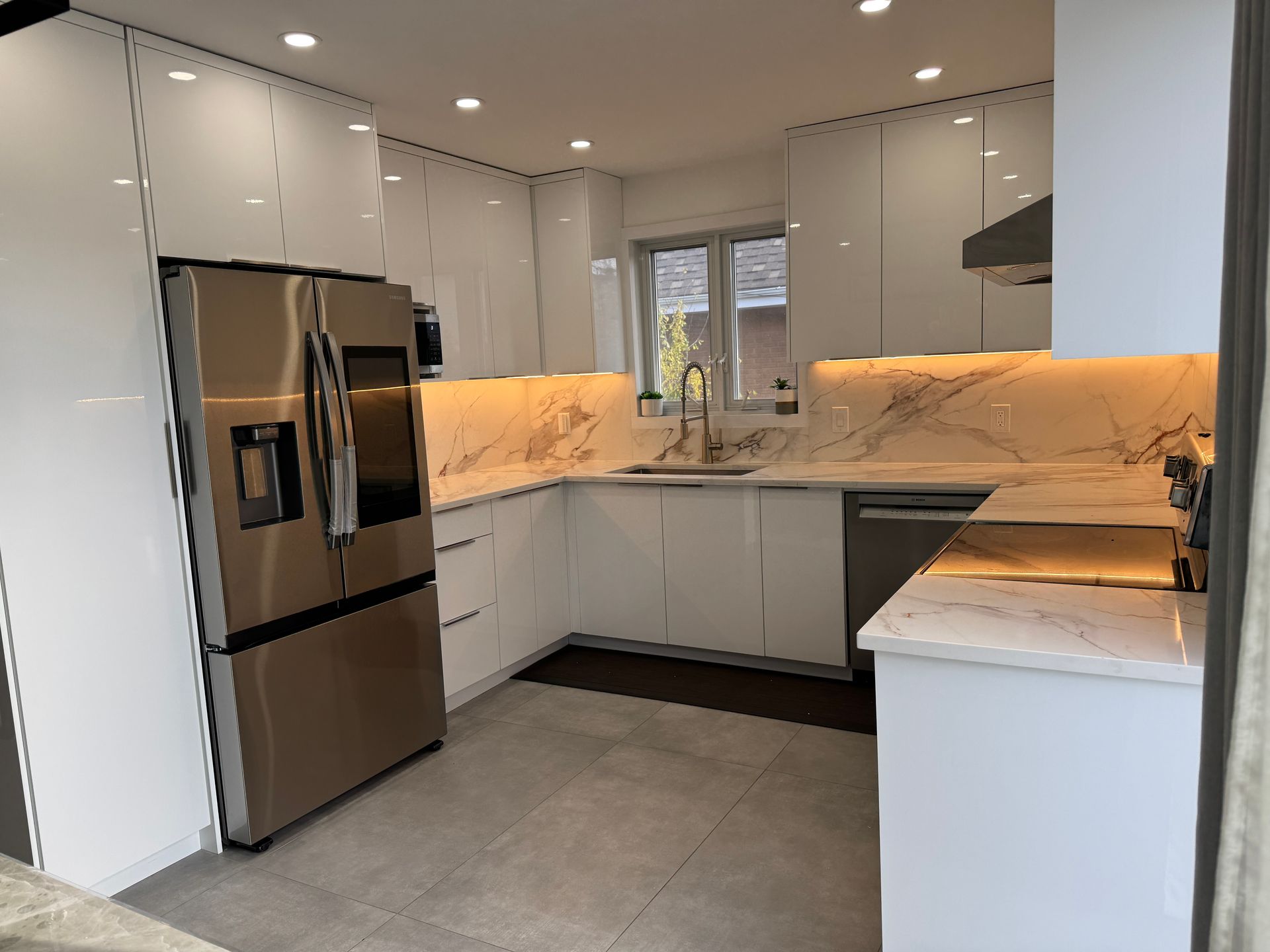 Une cuisine avec des armoires blanches et des appareils électroménagers en acier inoxydable.