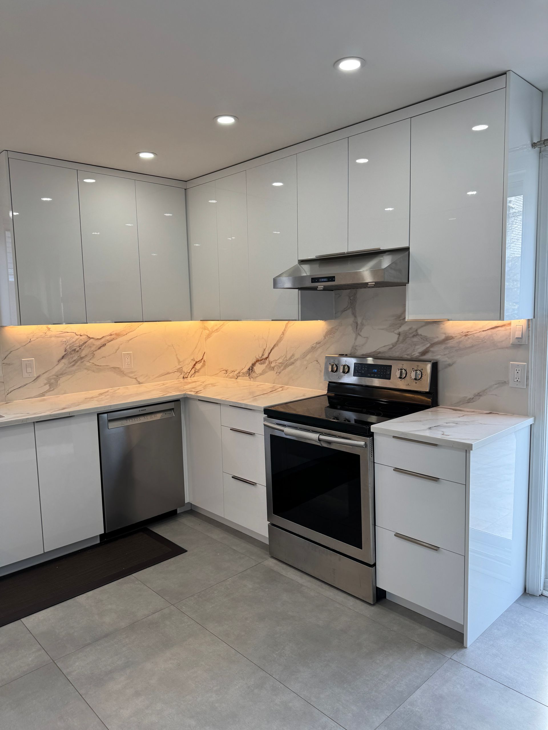 Une cuisine avec des armoires blanches et des appareils en acier inoxydable