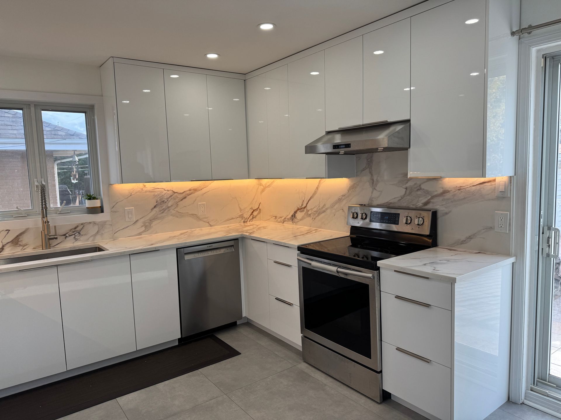 Une cuisine avec des armoires blanches et des appareils électroménagers en acier inoxydable.