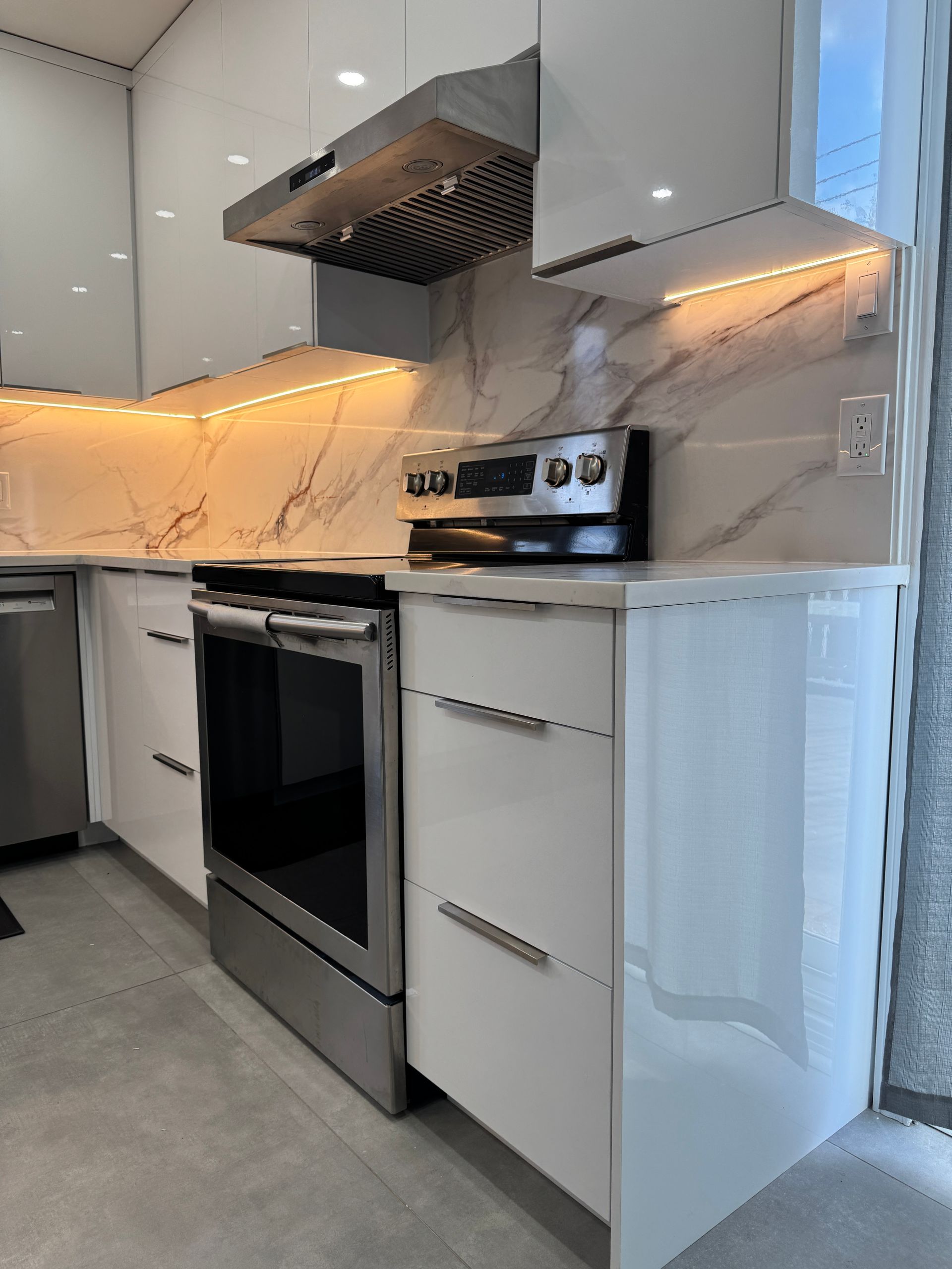 Une cuisine avec des appareils électroménagers en acier inoxydable et des armoires blanches.