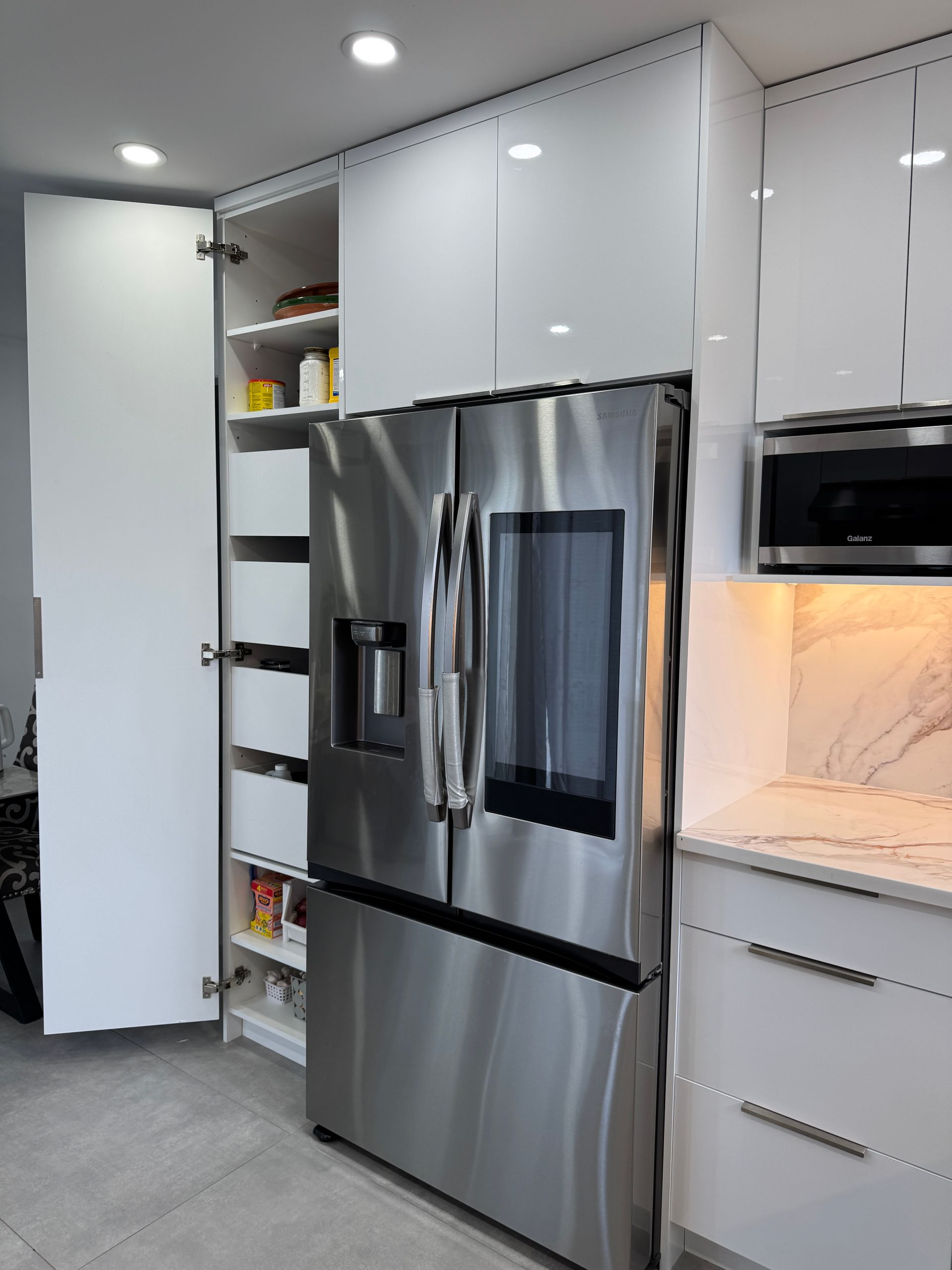 Une cuisine avec des appareils en acier inoxydable et des armoires blanches