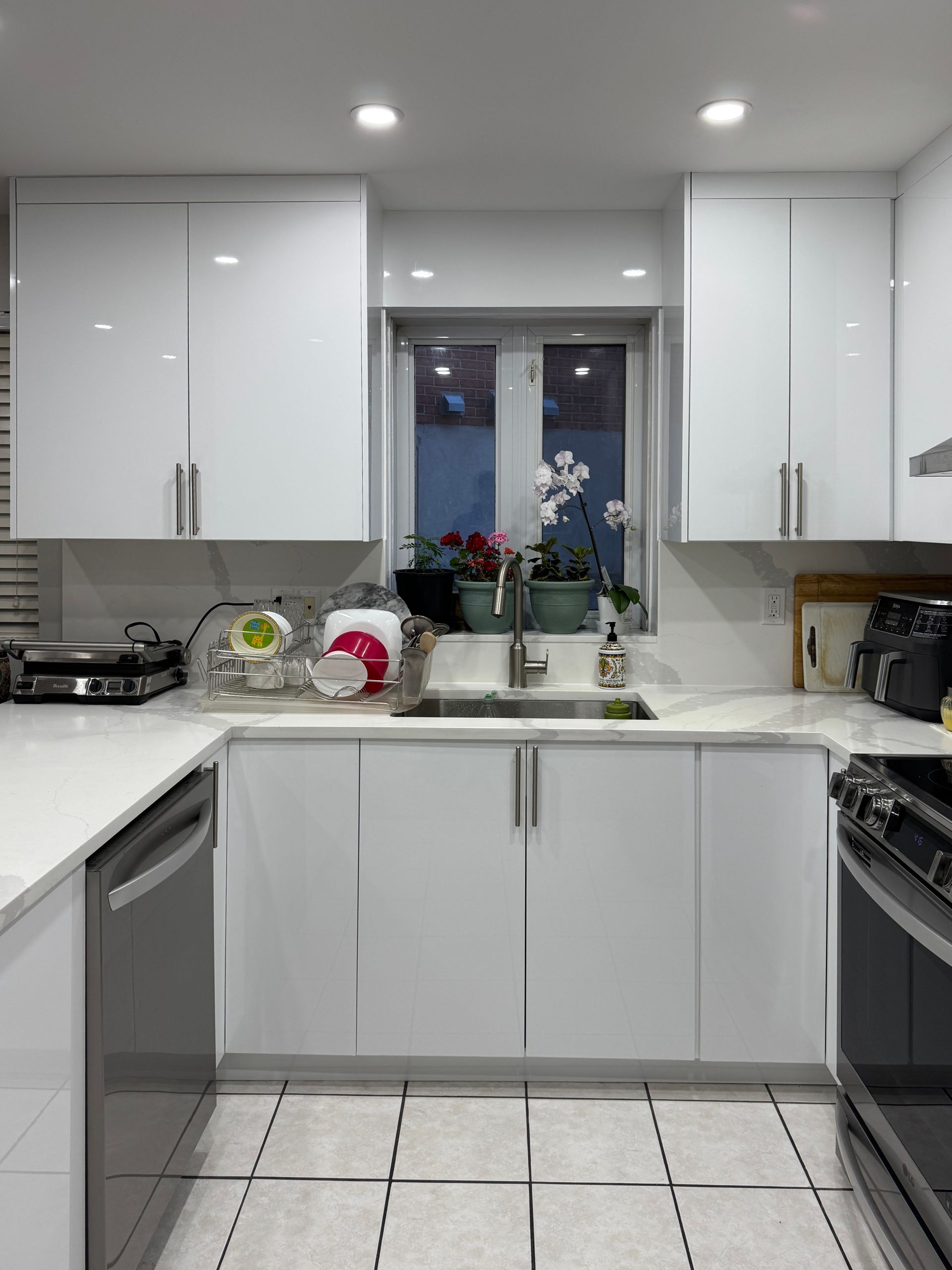 Une cuisine avec des armoires blanches et des appareils en acier inoxydable