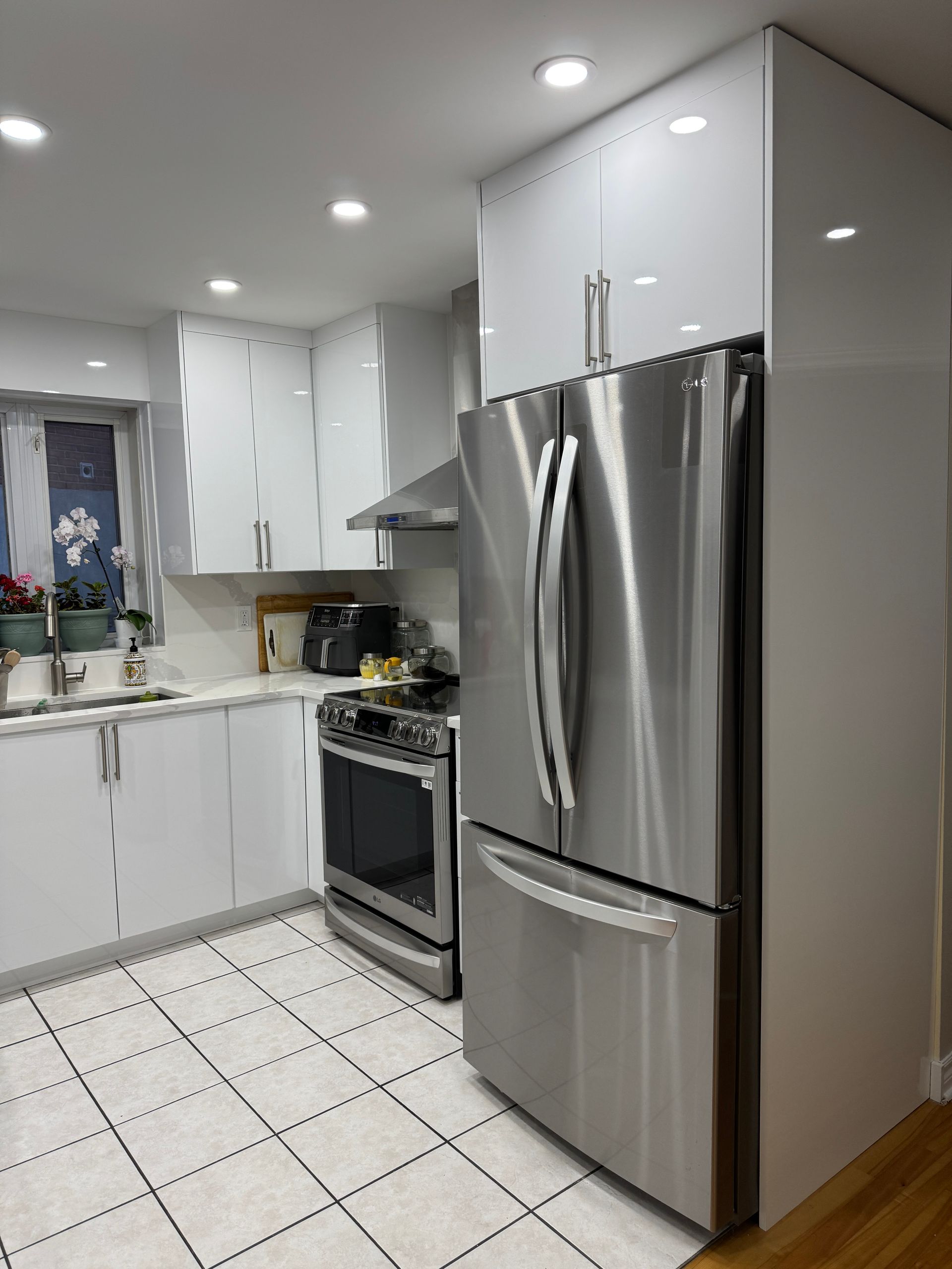 Une cuisine avec des appareils électroménagers en acier inoxydable et des armoires blanches.