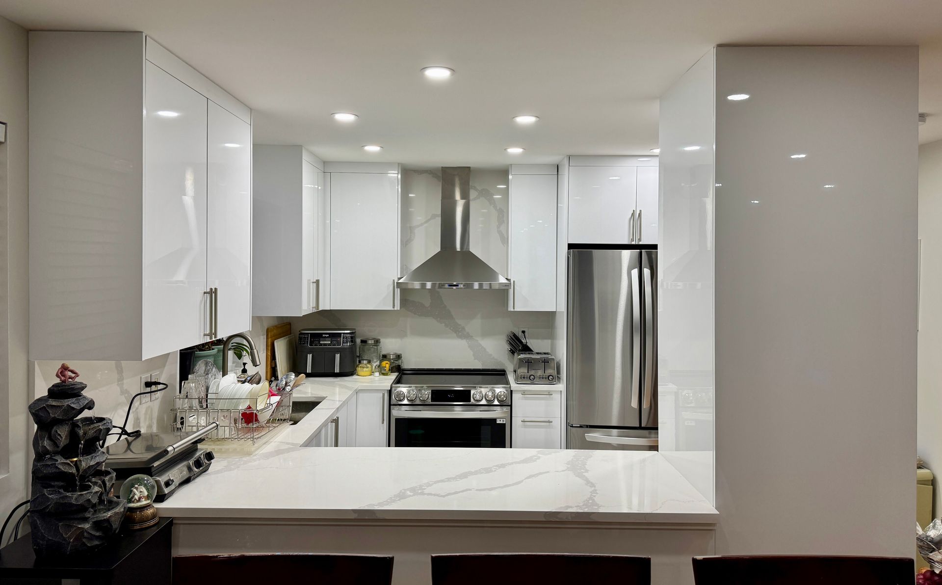 Une cuisine avec des armoires blanches et des appareils électroménagers en acier inoxydable.