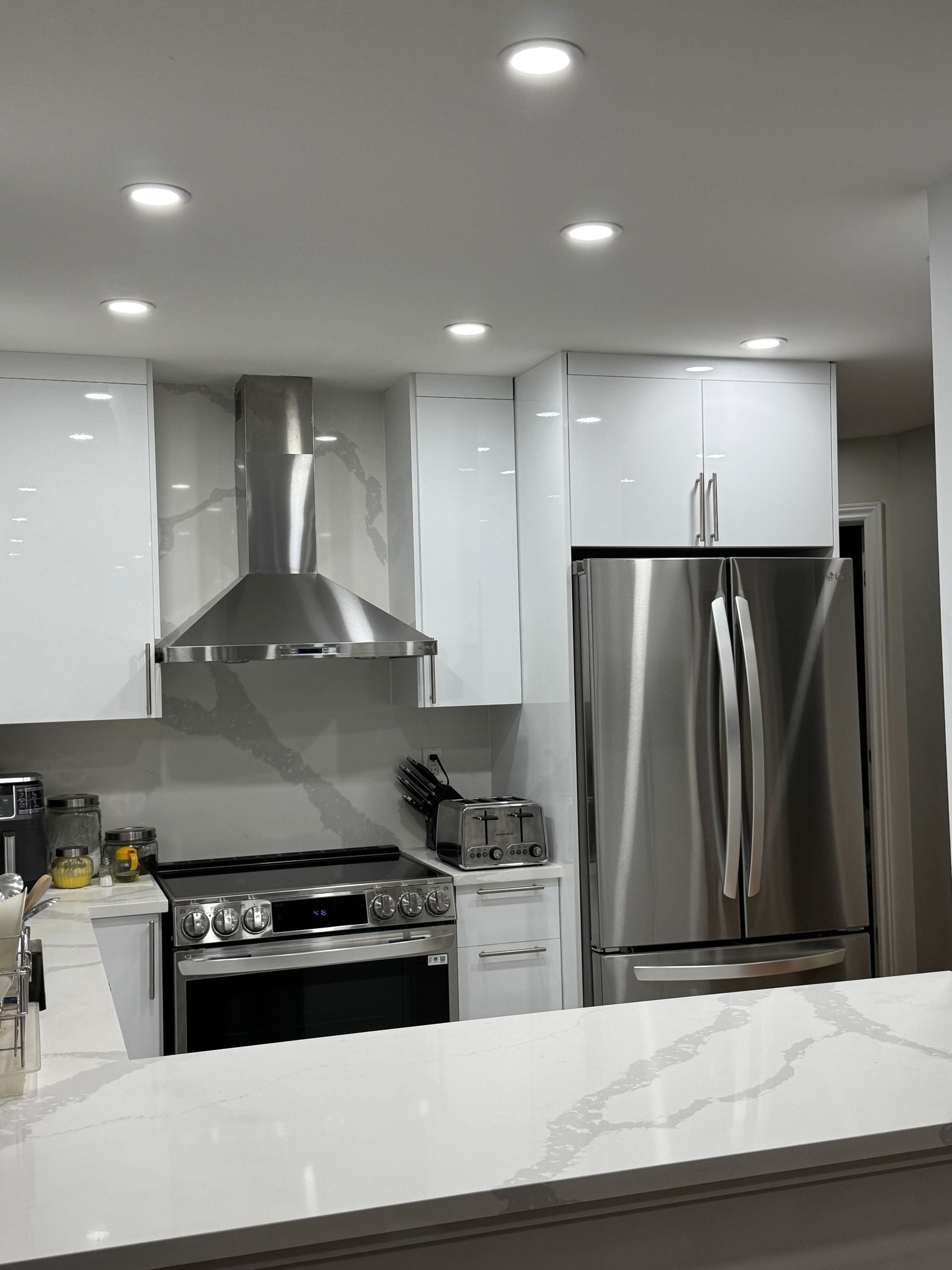 Une cuisine avec des appareils électroménagers en acier inoxydable et des armoires blanches.