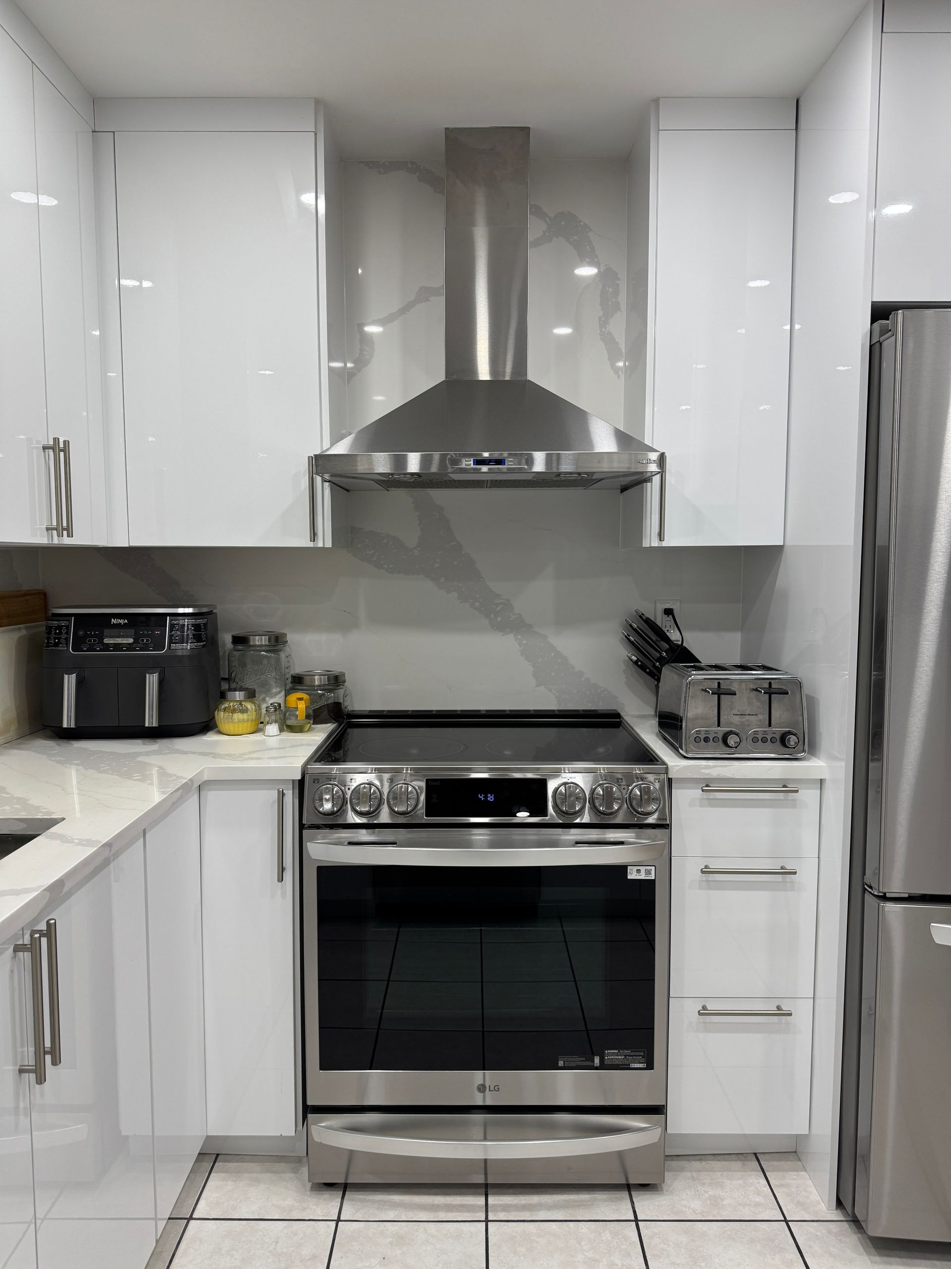 Une cuisine avec des appareils en acier inoxydable et des armoires blanches