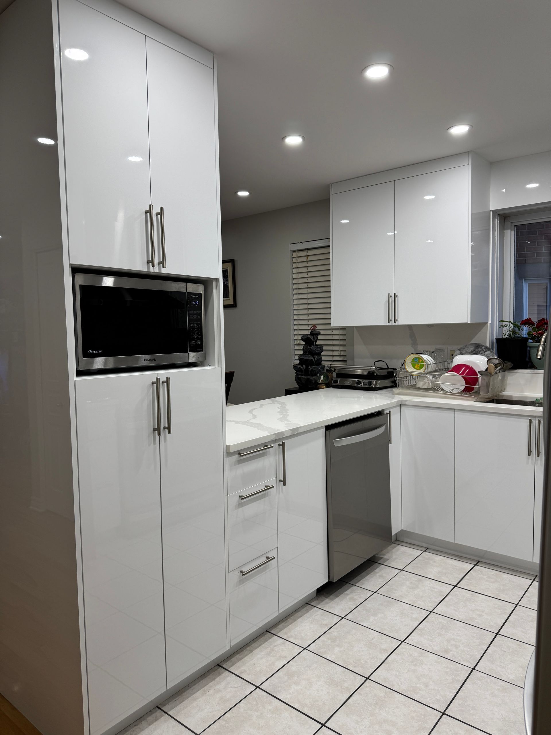 Une cuisine avec des armoires blanches et des appareils en acier inoxydable