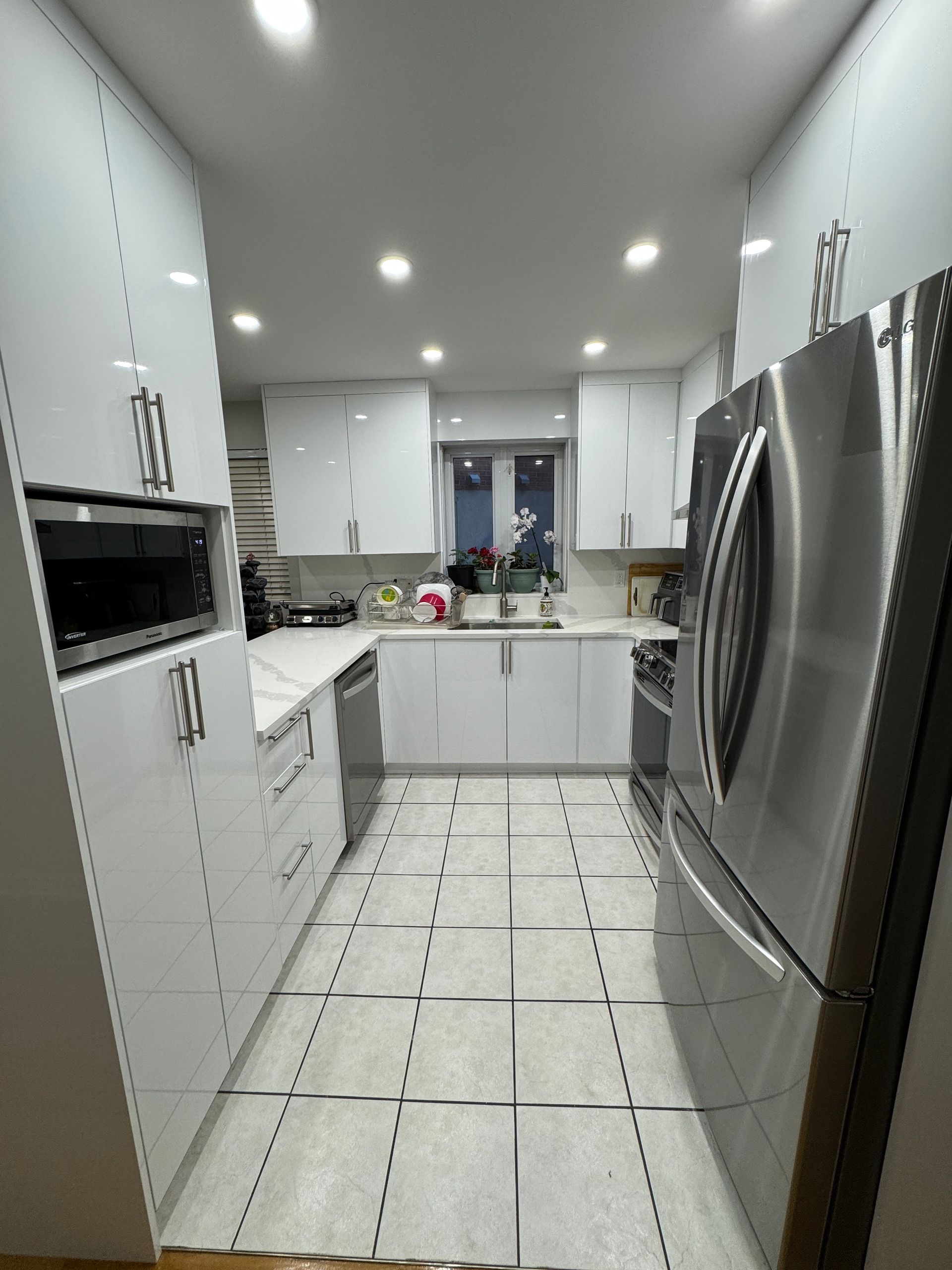 Une cuisine avec des armoires blanches et des appareils en acier inoxydable