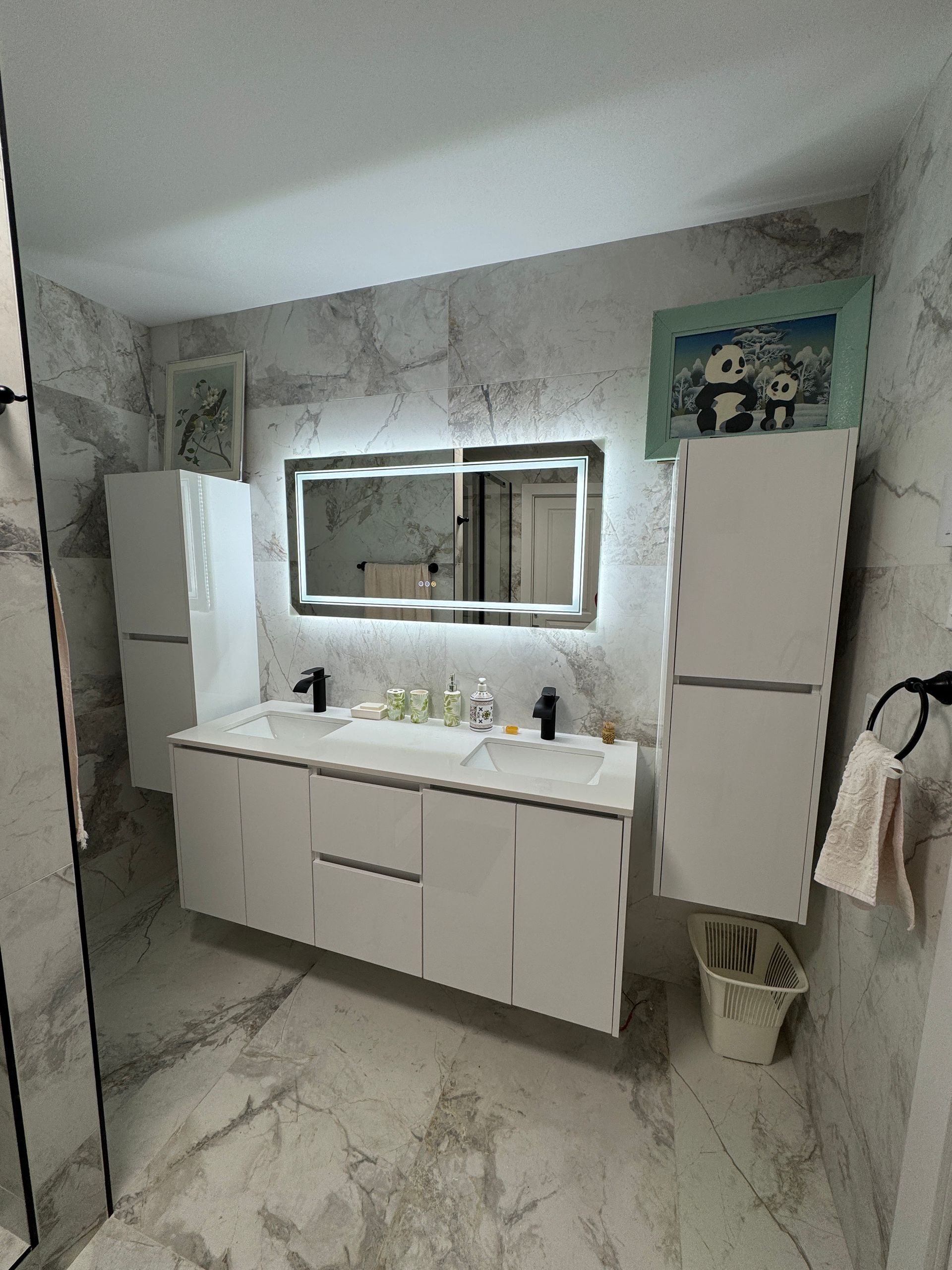 Une salle de bain avec deux lavabos et un miroir.