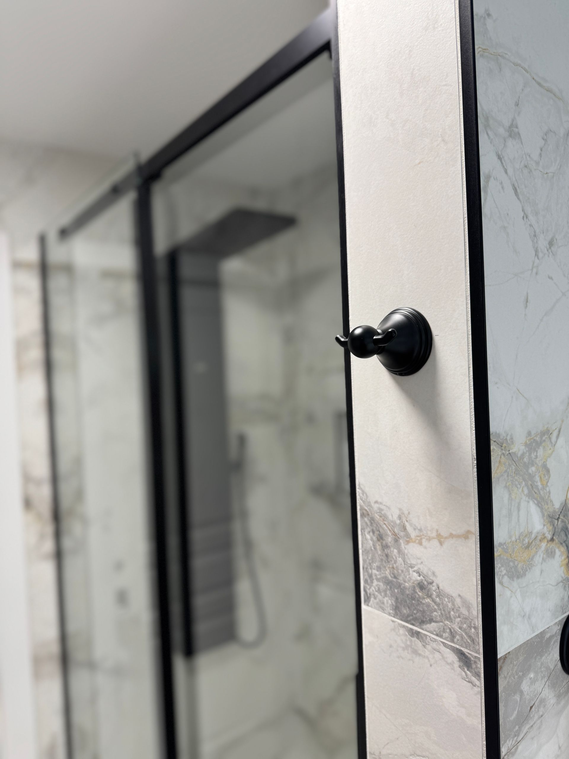 Une salle de bain avec une cabine de douche et un miroir.