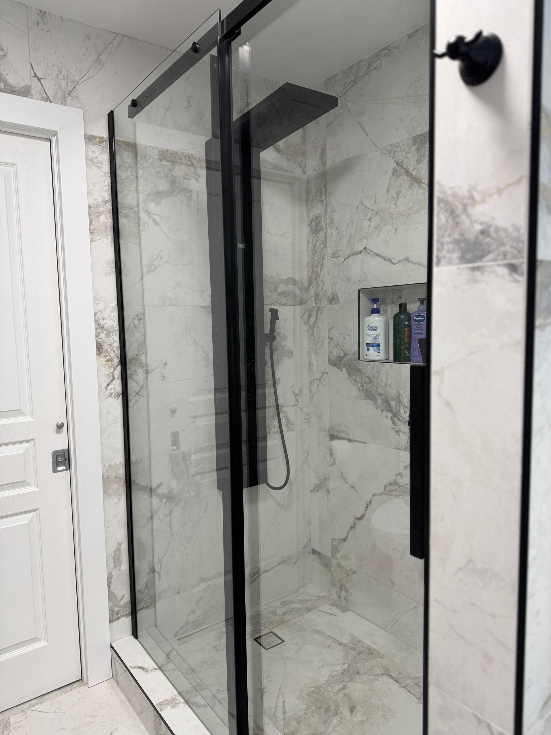 Une salle de bain avec douche à l'italienne et murs en marbre