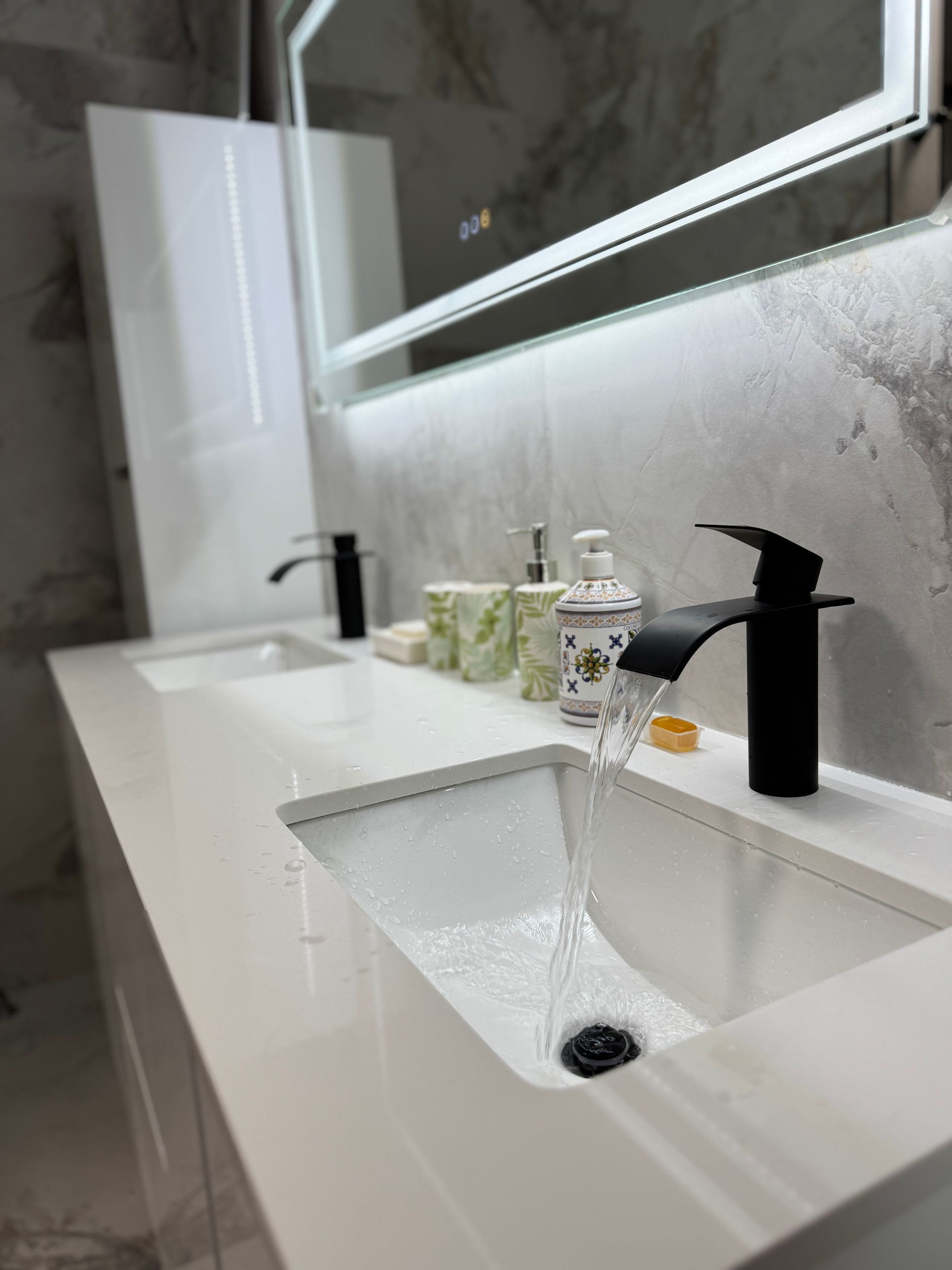 Une salle de bain avec deux lavabos et un miroir.