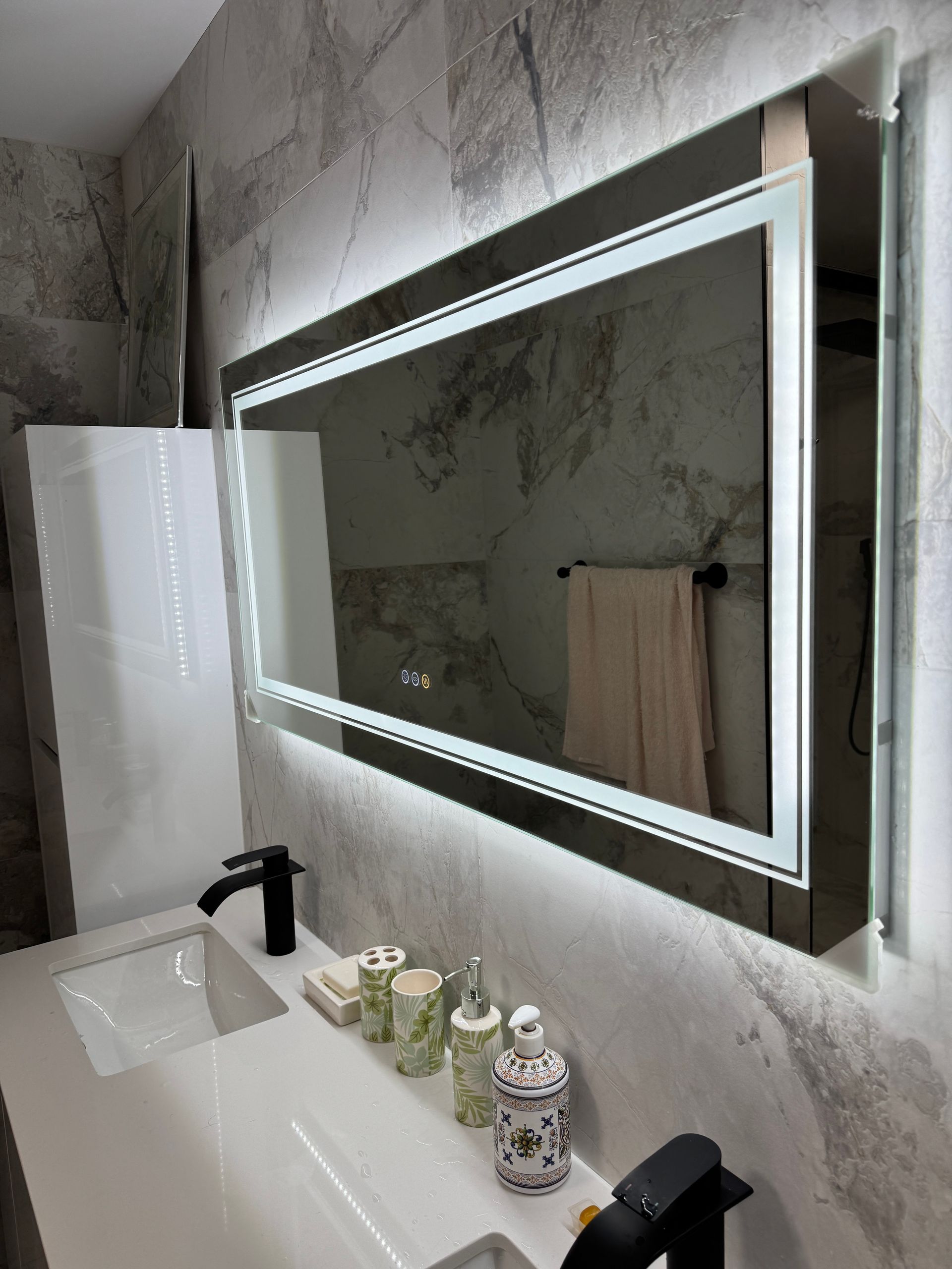 Une salle de bain avec un grand miroir et un lavabo.