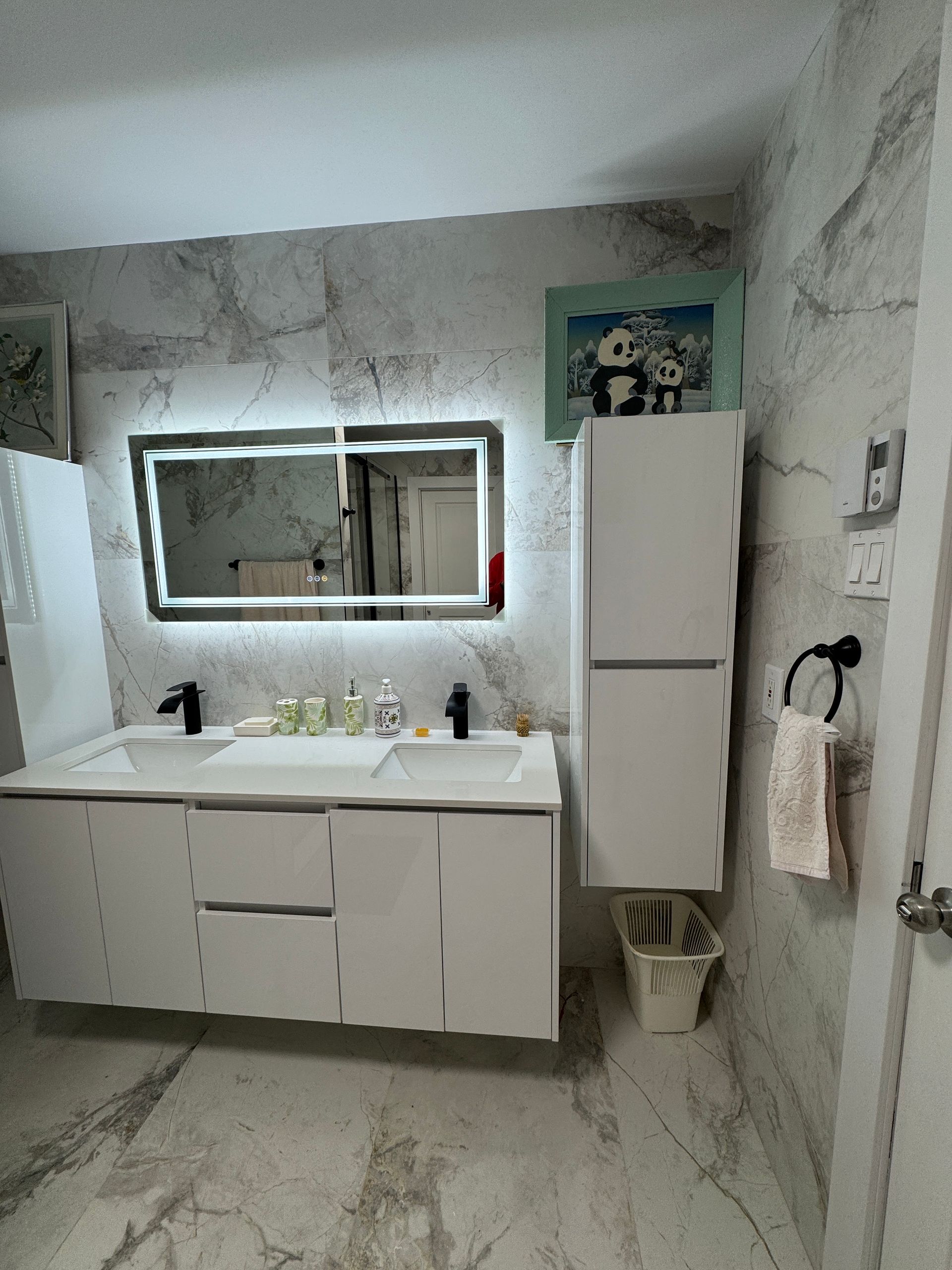 Une salle de bain avec deux lavabos et un grand miroir.