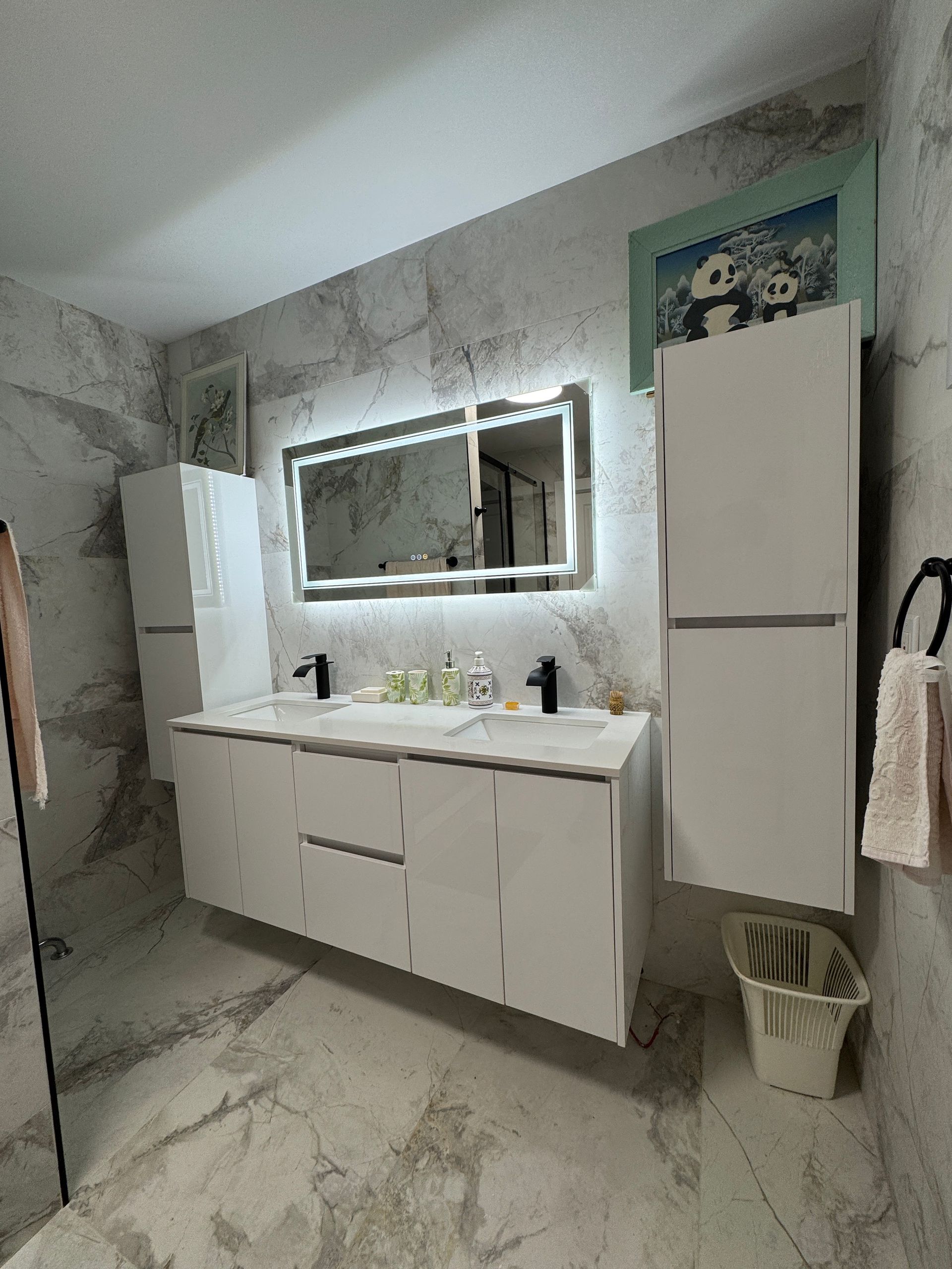 Une salle de bain avec deux lavabos et un grand miroir.