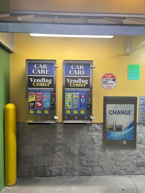 Black air hoses attached to orange bases in a gas station setting.