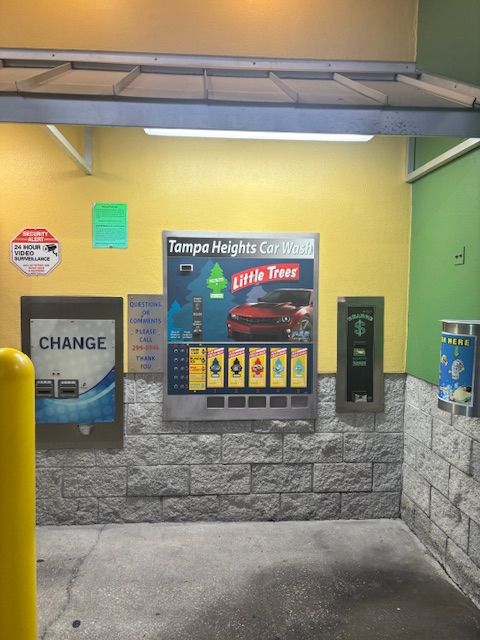A car being washed at a car wash, water spraying, close-up of tires and undercarriage.