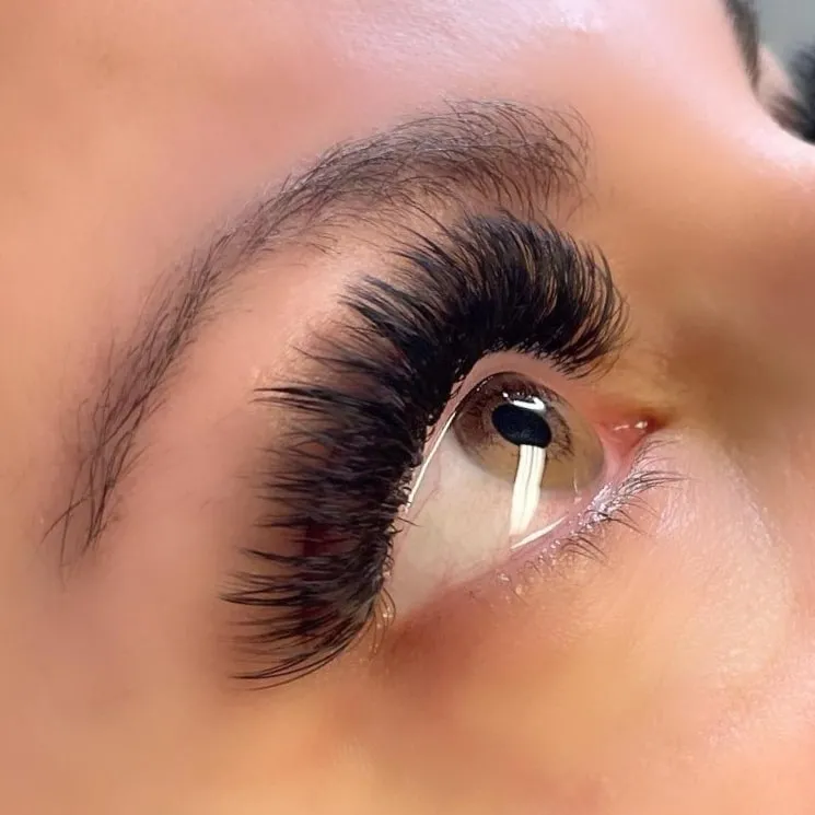 A close up of a woman 's eye with long eyelashes.